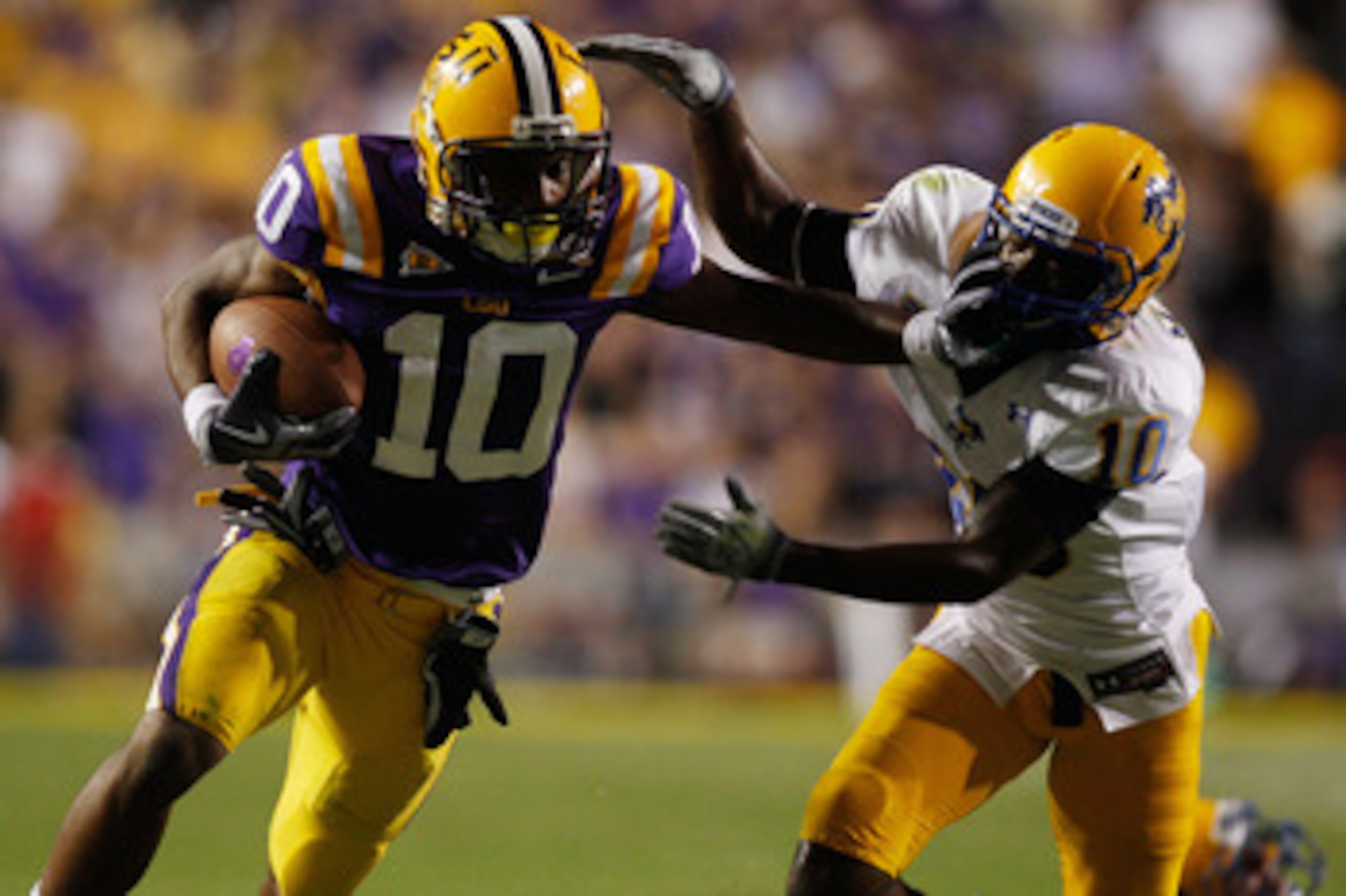 BATON ROUGE, LA - OCTOBER 16:  Russell Shepard #10 of the Louisiana State University Tigers is tackled by London Durham #10 of the McNeese State Cowboys at Tiger Stadium on October 16, 2010 in Baton Rouge, Louisiana.  The Tigers defeated the Cowboys 32-10