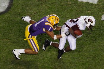 BATON ROUGE, LA - NOVEMBER 13:  Luther Ambrose #22 of the University of Louisiana-Monroe Warhawks is tackled by Eric Reid #1 of the Louisiana State University Tigers at Tiger Stadium on November 13, 2010 in Baton Rouge, Louisiana.  The Tigers defeated the