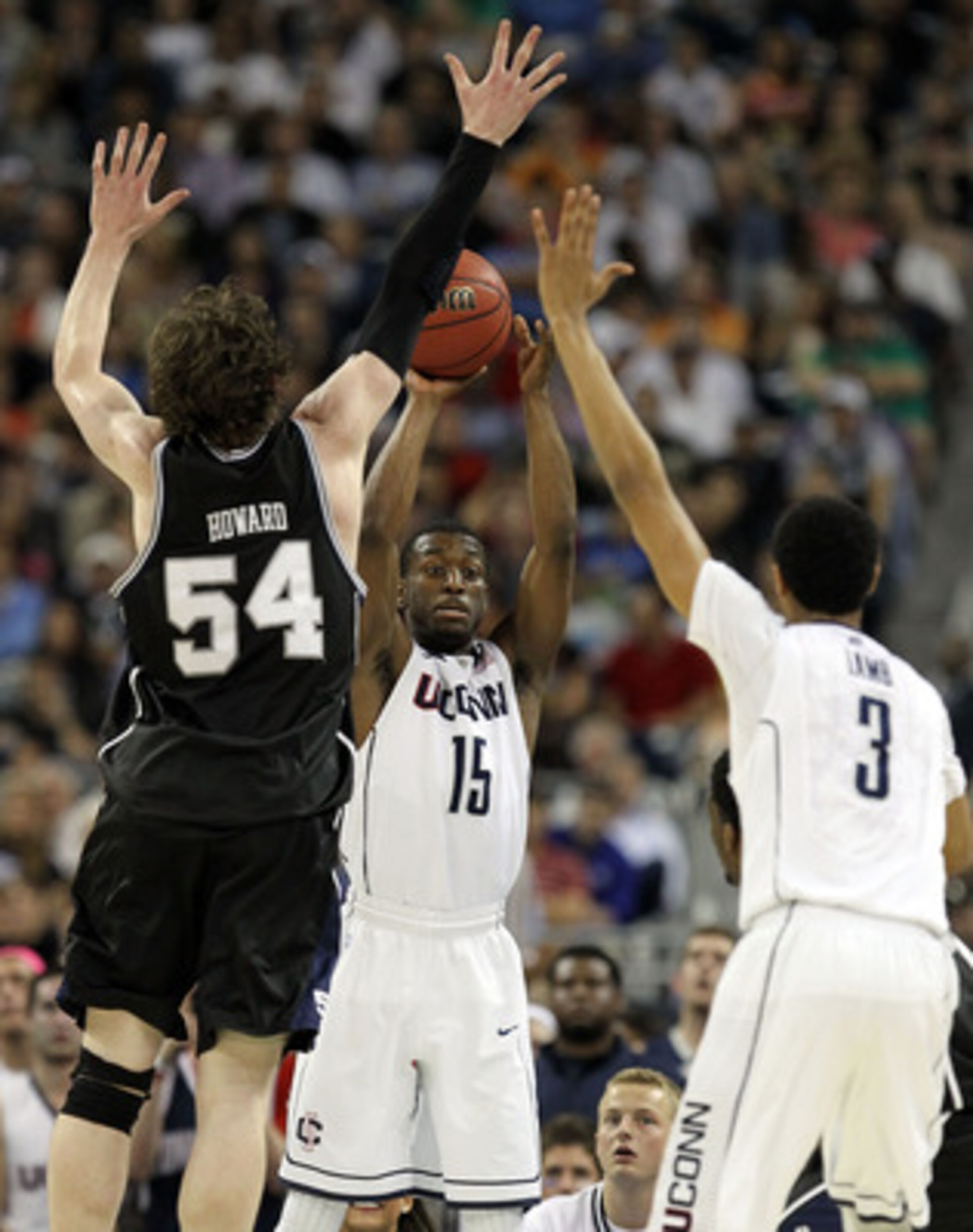 HOUSTON, TX - APRIL 04:  Kemba Walker #15 of the Connecticut Huskies looks to pass the ball to teammate Jeremy Lamb #3 over the arms of Matt Howard #54 of the Butler Bulldogs during the National Championship Game of the 2011 NCAA Division I Men's Basketba