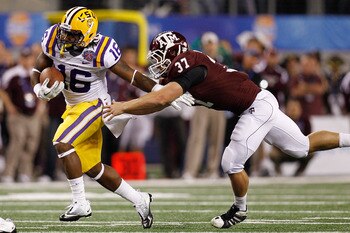 ARLINGTON, TX - JANUARY 07:  Spencer Ware #16 of the Louisiana State University Tigers is tackled by Michael Hodges #37 of the Texas A&M Aggies during the AT&T Cotton Bowl at Cowboys Stadium on January 7, 2011 in Arlington, Texas.  (Photo by Chris Graythe