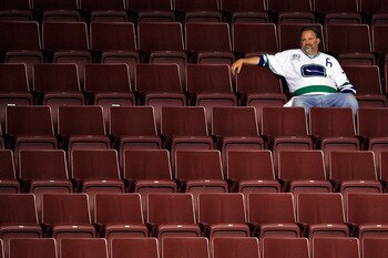 VANCOUVER, BC - JUNE 15:  A Vancouver Canucks fan sits in empty seats after the Vancouver Canucks were defeated by the Boston Bruins in Game Seven of the 2011 NHL Stanley Cup Final at Rogers Arena on June 15, 2011 in Vancouver, British Columbia, Canada. T