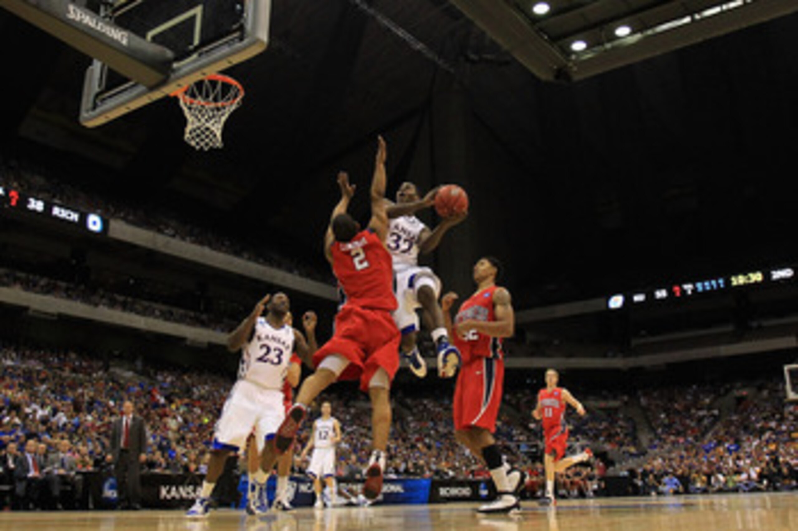SAN ANTONIO, TX - MARCH 25:  Josh Selby #32 of the Kansas Jayhawks goes to the basket against Cedrick Lindsay #2 of the Richmond Spiders during the southwest regional of the 2011 NCAA men's basketball tournament at the Alamodome on March 25, 2011 in San A