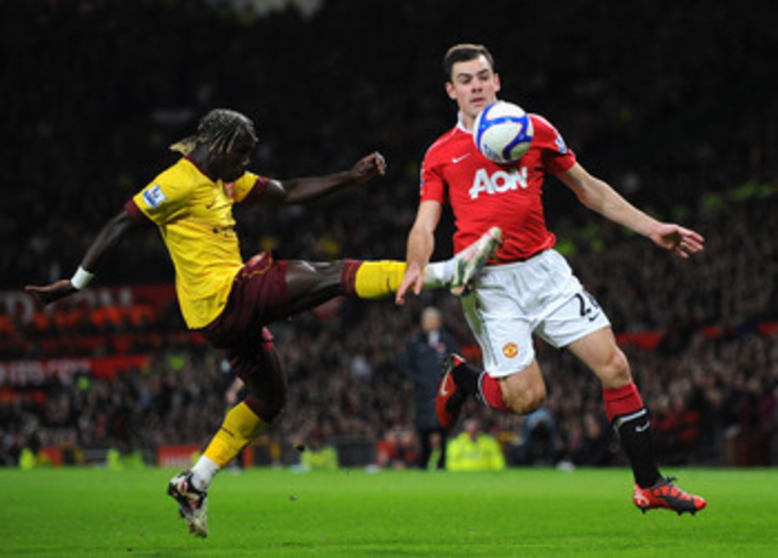 MANCHESTER, ENGLAND - MARCH 12:  Bacary Sagna of Arsenal and Darron Gibson of Manchester United battle for the ball during the FA Cup sponsored by E.On Sixth Round match between Manchester United and Arsenal at Old Trafford on March 12, 2011 in Manchester