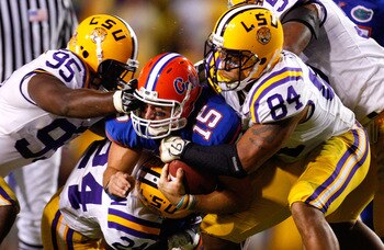 BATON ROUGE, LA - OCTOBER 10:  Quarterback Tim Tebow #15 of the Florida Gators is tackled by Lazarius Levingston #95, Harry Coleman #24 and Rahim Alem #84 of the Louisiana State University Tigers at Tiger Stadium on October 10, 2009 in Baton Rouge, Louisi