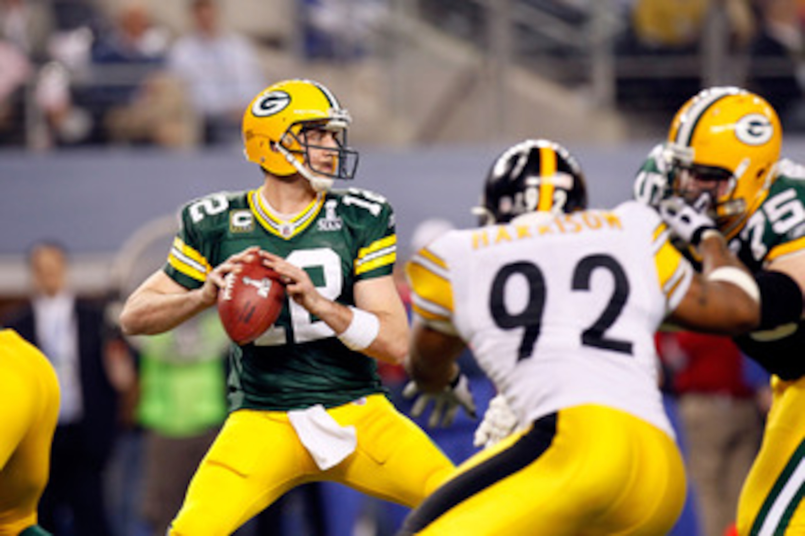 ARLINGTON, TX - FEBRUARY 06:  Aaron Rodgers #12 of the Green Bay Packers looks to pass against James Harrison #92 of the Pittsburgh Steelers during Super Bowl XLV at Cowboys Stadium on February 6, 2011 in Arlington, Texas. The Packers won 31-25.  (Photo b