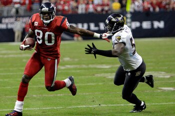HOUSTON, TX - DECEMBER 13:  Wide receiver Andre Johnson #80 of the Houston Texans fends off  linebacker Jameel McClain #63 of the Baltimore Ravens as he gains a first down late in the fourth quarter at Reliant Stadium on December 13, 2010 in Houston, Texa