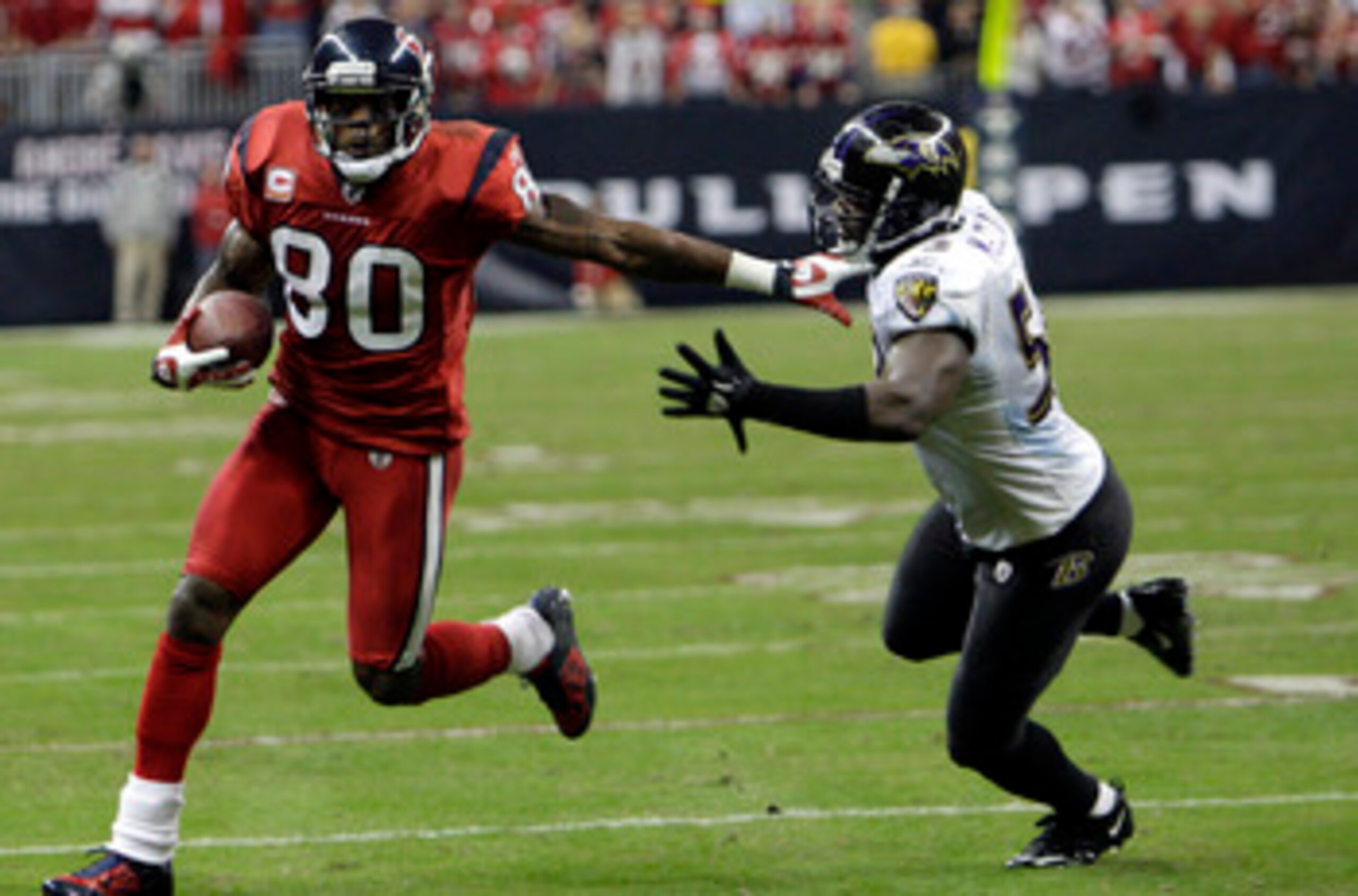 HOUSTON, TX - DECEMBER 13:  Wide receiver Andre Johnson #80 of the Houston Texans fends off  linebacker Jameel McClain #63 of the Baltimore Ravens as he gains a first down late in the fourth quarter at Reliant Stadium on December 13, 2010 in Houston, Texa
