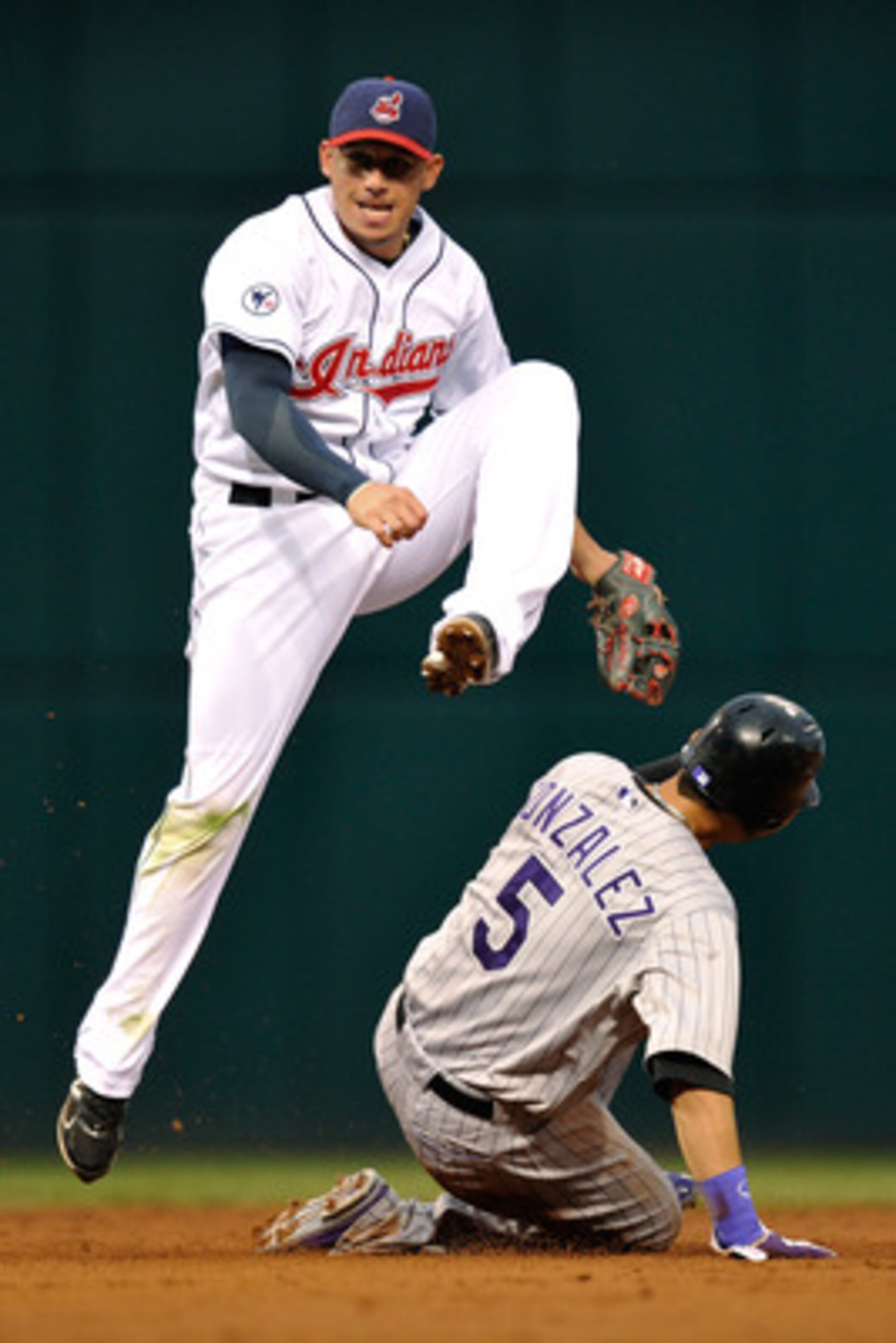 CLEVELAND, OH - JUNE 20: Asdrubal Cabrera #13 of the Cleveland Indians leaps over Carlos Gonzalez #5 of the Colorado Rockies as he completes a double play in the third inning at Progressive Field on June 20, 2011 in Cleveland, Ohio. (Photo by Jamie Saba CLEVELAND, OH - JUNE 20: Asdrubal Cabrera #13 of the Cleveland Indians leaps over Carlos Gonzalez #5 of the Colorado Rockies as he completes a double play in the third inning at Progressive Field on June 20, 2011 in Cleveland, Ohio. (Photo by Jamie Saba
