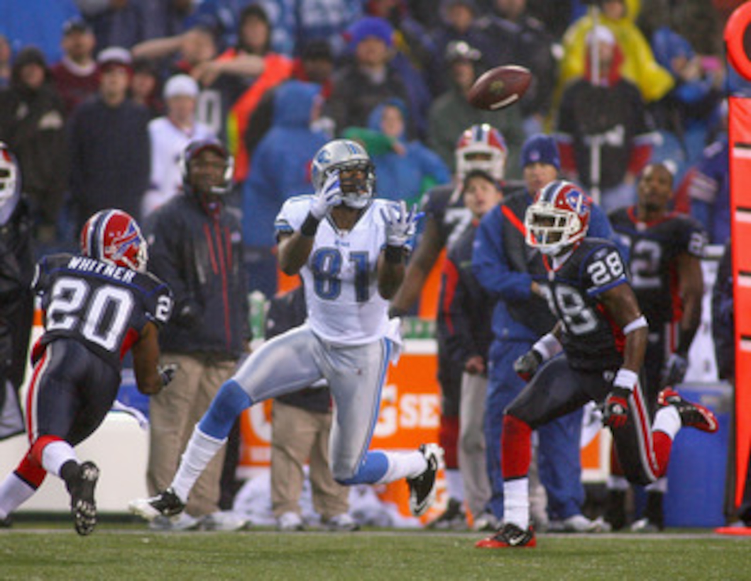 ORCHARD PARK, NY - NOVEMBER 14:  Calvin Johnson #81 of the Detroit Lions catches a pass between Donte Whitner #20 and Leodis McKelvin #28 of the Buffalo Bills at Ralph Wilson Stadium on November 14, 2010 in Orchard Park, New York. The Bills won 14-12.  (P