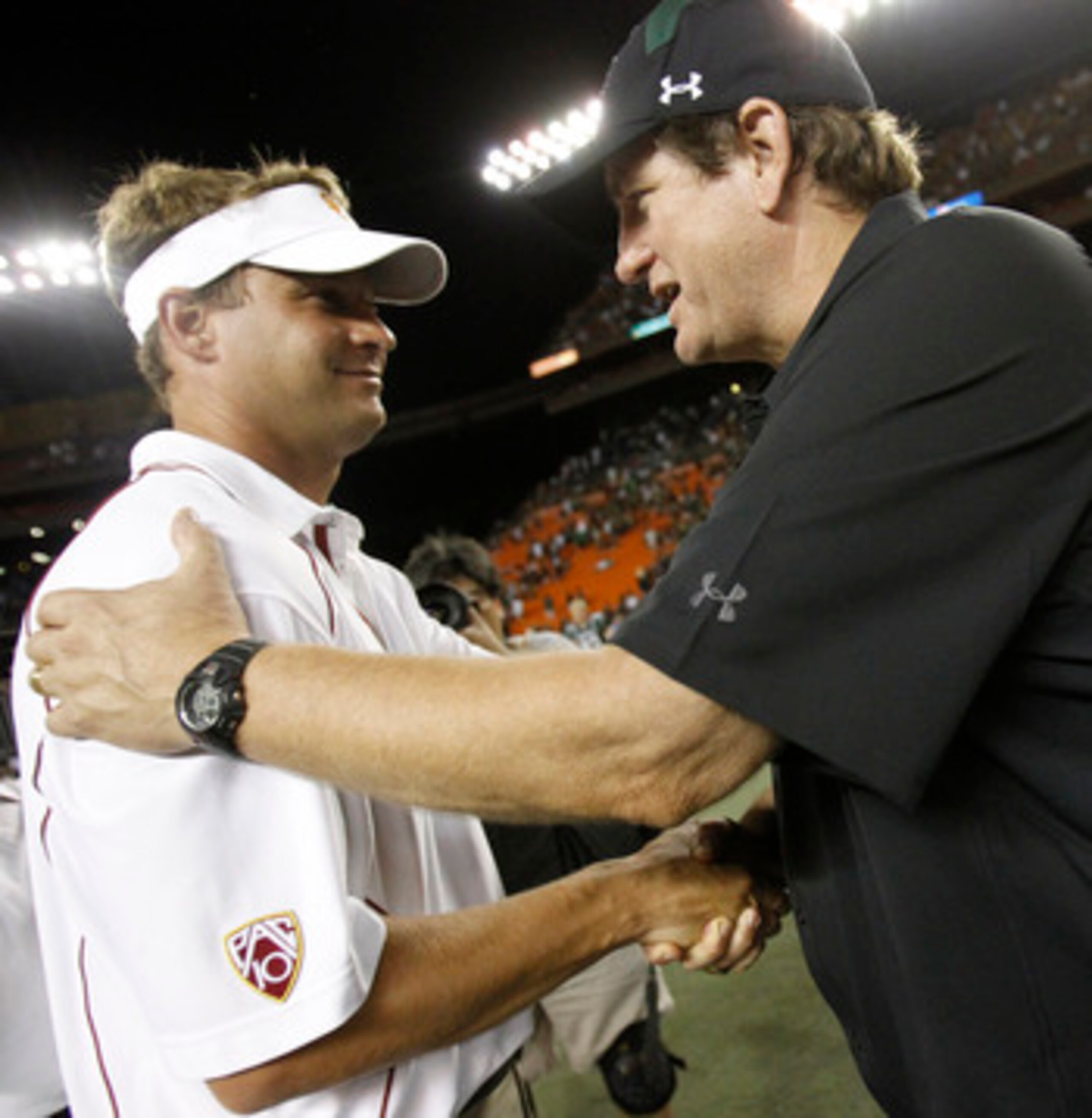 HONOLULU - SEPTEMBER 02: Head Coach Lane Kaffin of the University of Southern California Trojans shakes hands with Assistant coach Gordon Shaw of the University of Hawaii Warriors after the Trojans defeated the Warriors 49-36 at Aloha Stadium September 2,