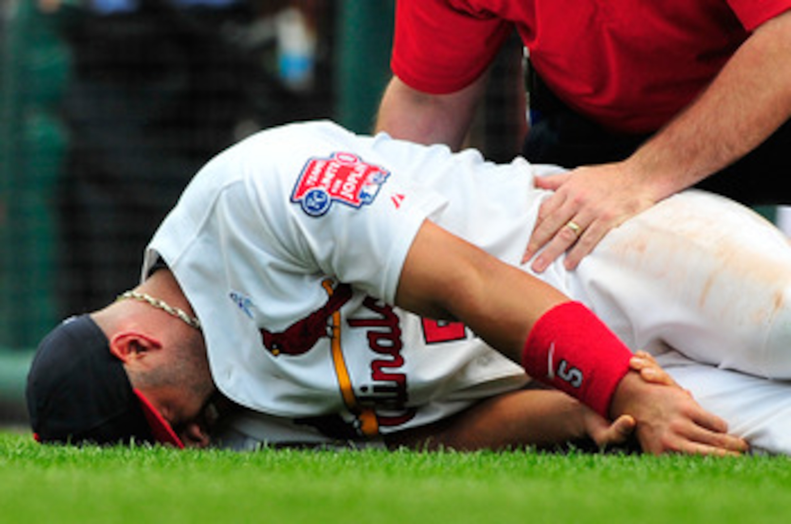 ST. LOUIS, MO - JUNE 19: Albert Pujols #5 of the St. Louis Cardinals holds his wrist after a collision with Wilson Betemit #24 of the Kansas City Royals at Busch Stadium on June 19, 2011 in St. Louis, Missouri.  (Photo by Jeff Curry/Getty Images)