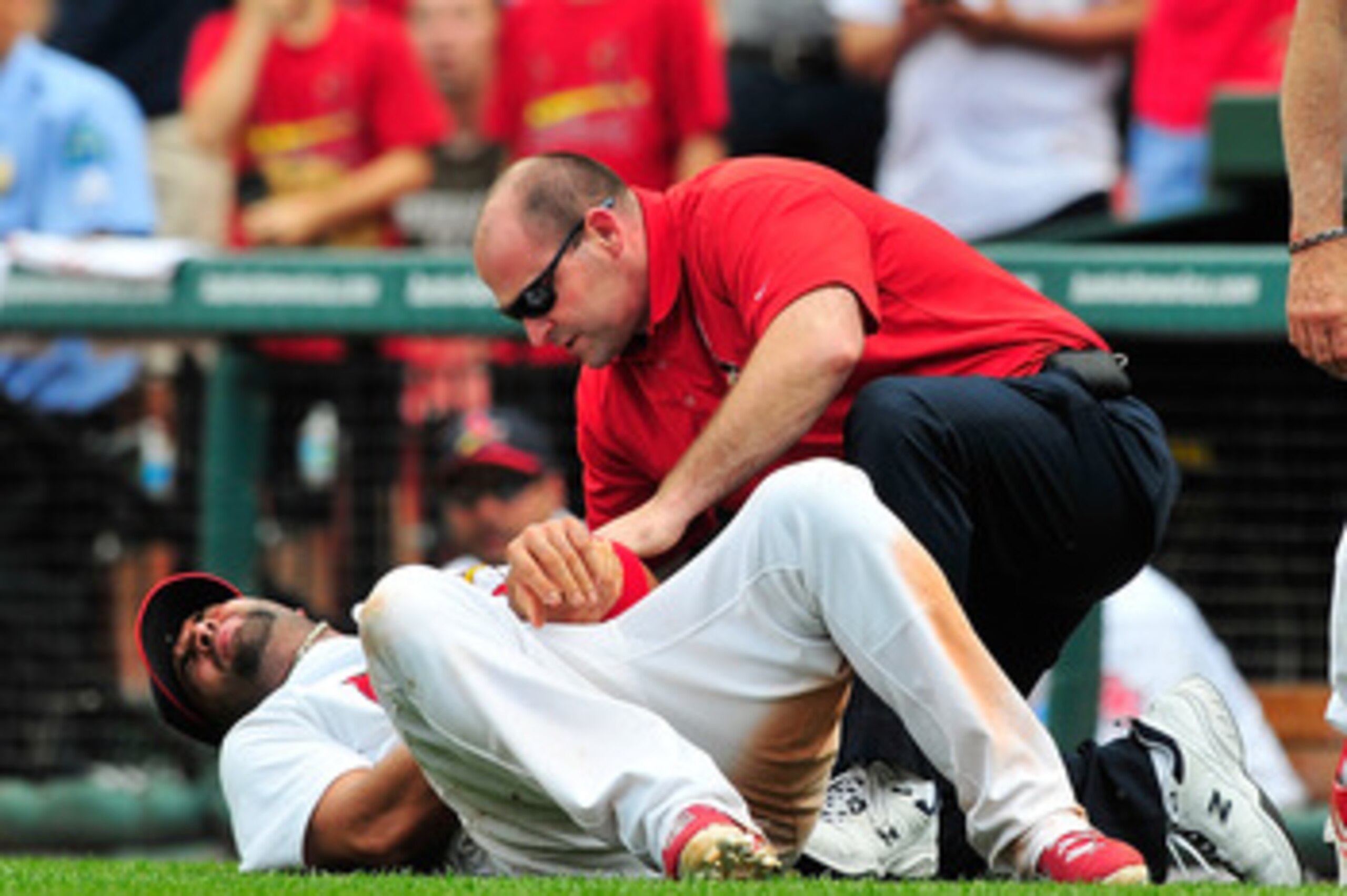 ST. LOUIS, MO - JUNE 19: Albert Pujols #5 of the St. Louis Cardinals holds his wrist after a collision with Wilson Betemit #24 of the Kansas City Royals as Tony La Russa #10 looks on at Busch Stadium on June 19, 2011 in St. Louis, Missouri.  (Photo by Jef