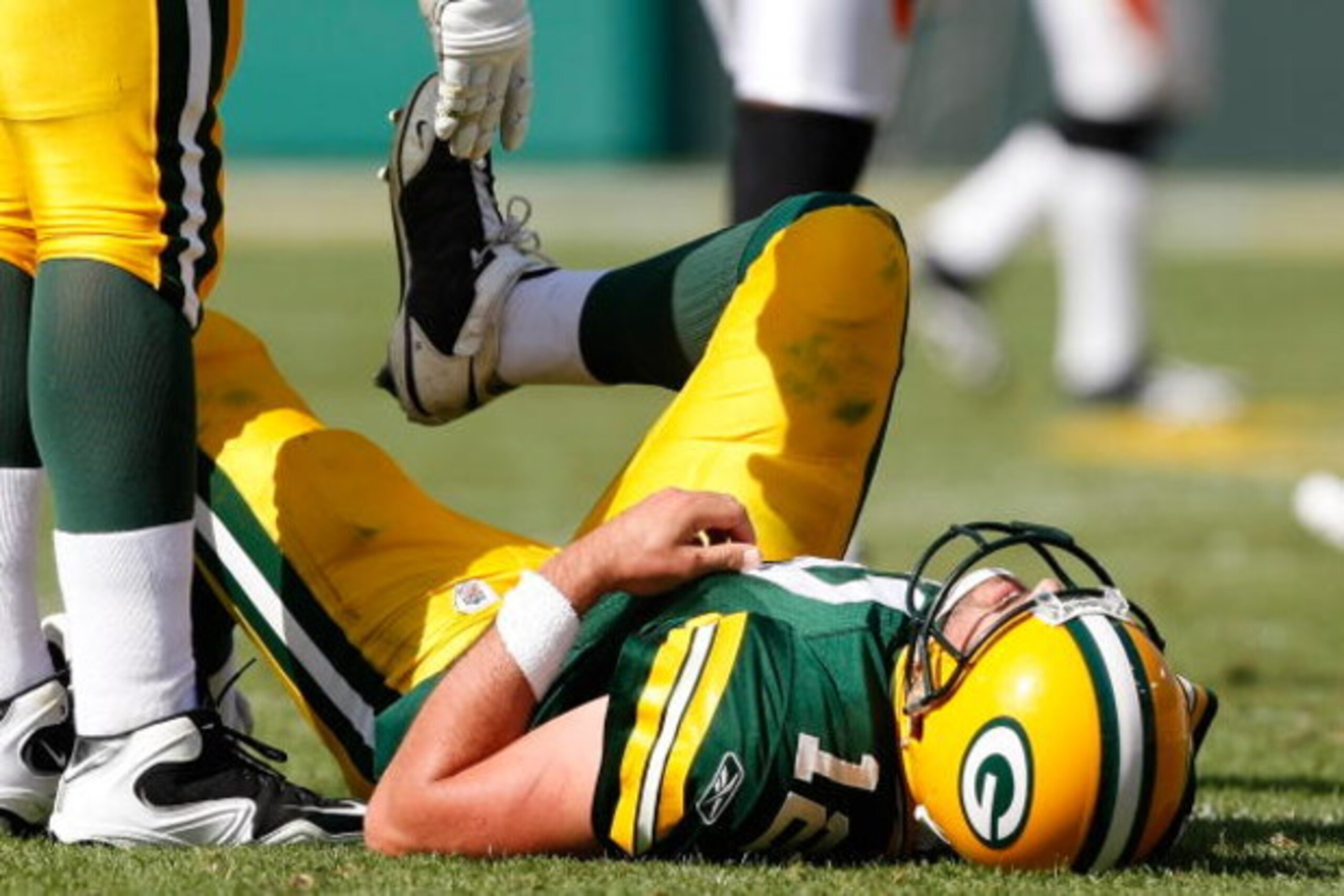 GREEN BAY, WI - SEPTEMBER 20: Quarterback Aaron Rogers #12 of the Green Bay Packers lays on the field after he was sacked in the 4th quarter against the Cincinnati Bengals at Lambeau Field on September 20, 2009 in Green Bay, Wisconsin. The Bengals defeate