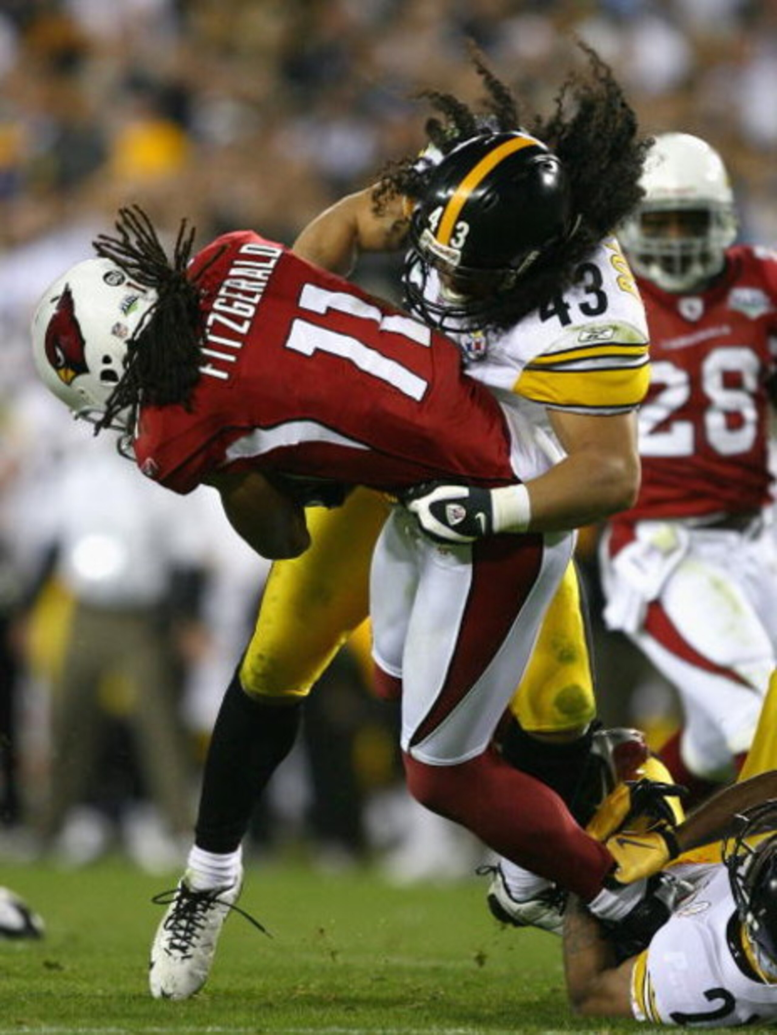 TAMPA, FL - FEBRUARY 01:  Larry Fitzgerald #11 of the Arizona Cardinals gets tackled by Troy Polamalu #43 of the Pittsburgh Steelers in the fourth quarter during Super Bowl XLIII on February 1, 2009 at Raymond James Stadium in Tampa, Florida.  (Photo by A