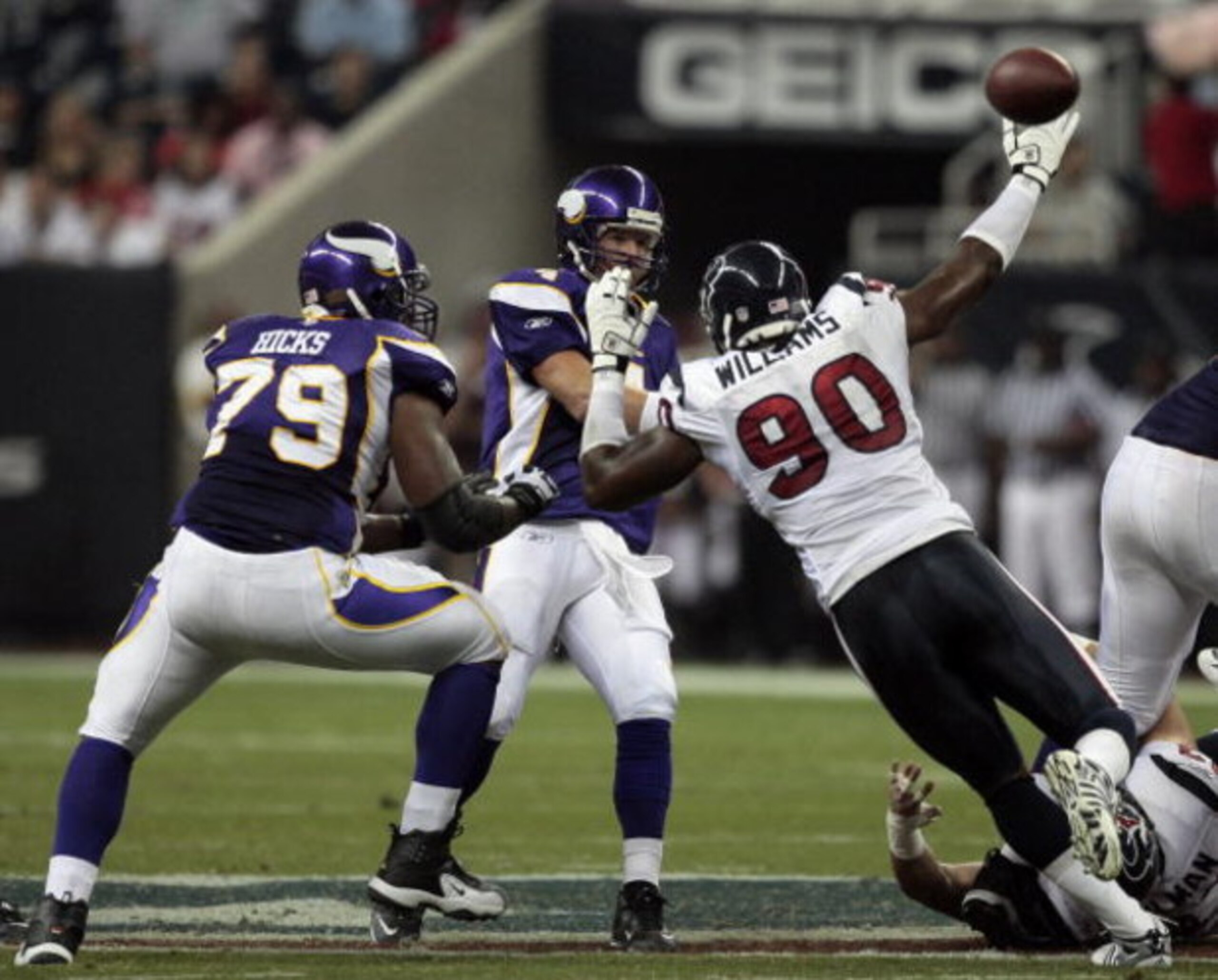 HOUSTON - AUGUST 31:  Quarterback Brett Favre #4 of the Minnestoa Vikings releases the ball as he is pressured by defensive end Mario Williams #90 of the Houston Texans at Reliant Stadium on August 31, 2009 in Houston, Texas.  (Photo by Bob Levey/Getty Im