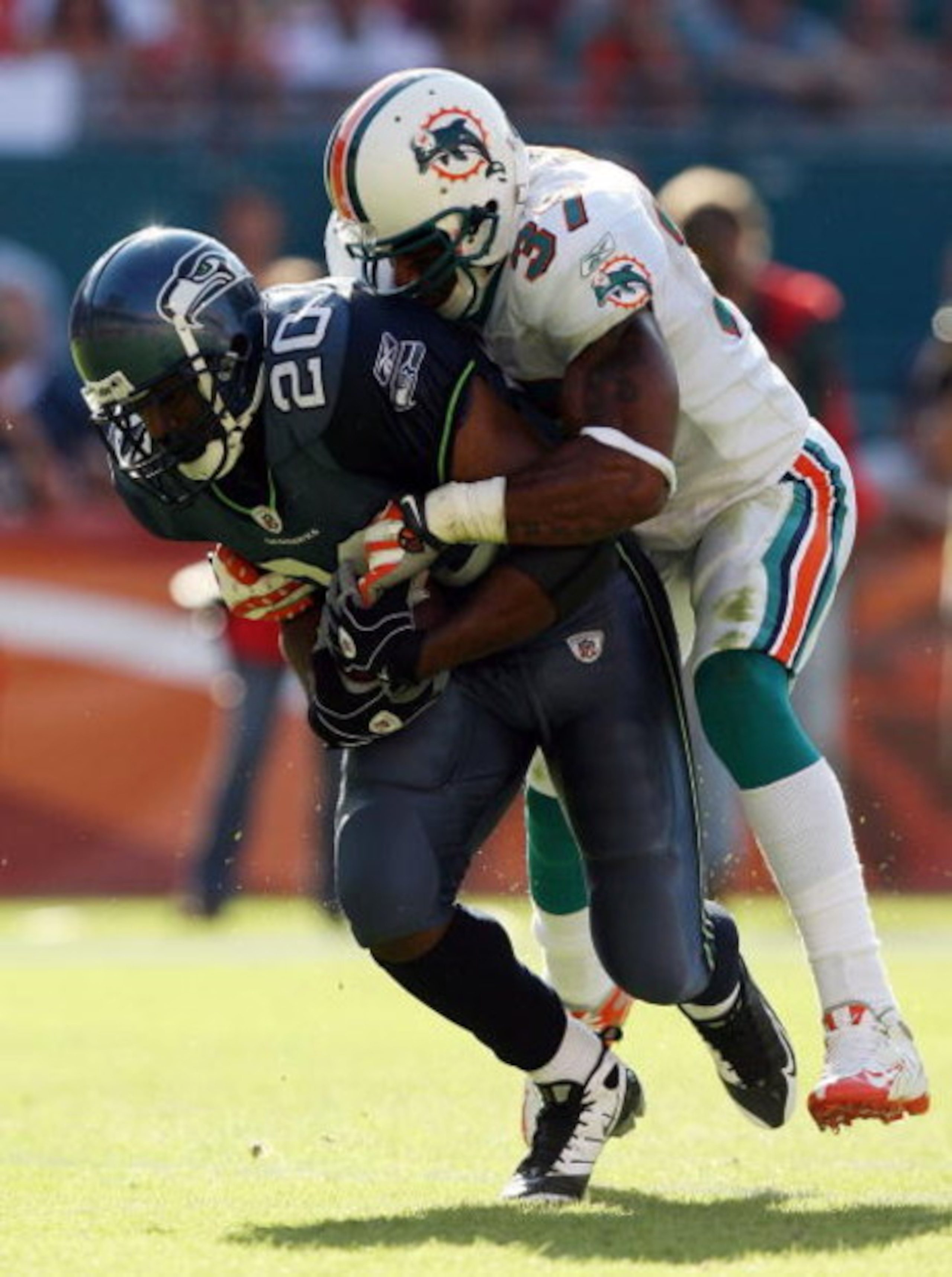 MIAMI - NOVEMBER 09:  Running back Maurice Morris #20 of the Seattle Seahawks is brought down by safety Yeremiah Bell #37 of the Miami Dolphins at Dolphin Stadium on November 9, 2008 in Miami, Florida. The Dolphins defeated the Seahawks 21-19.  (Photo by 