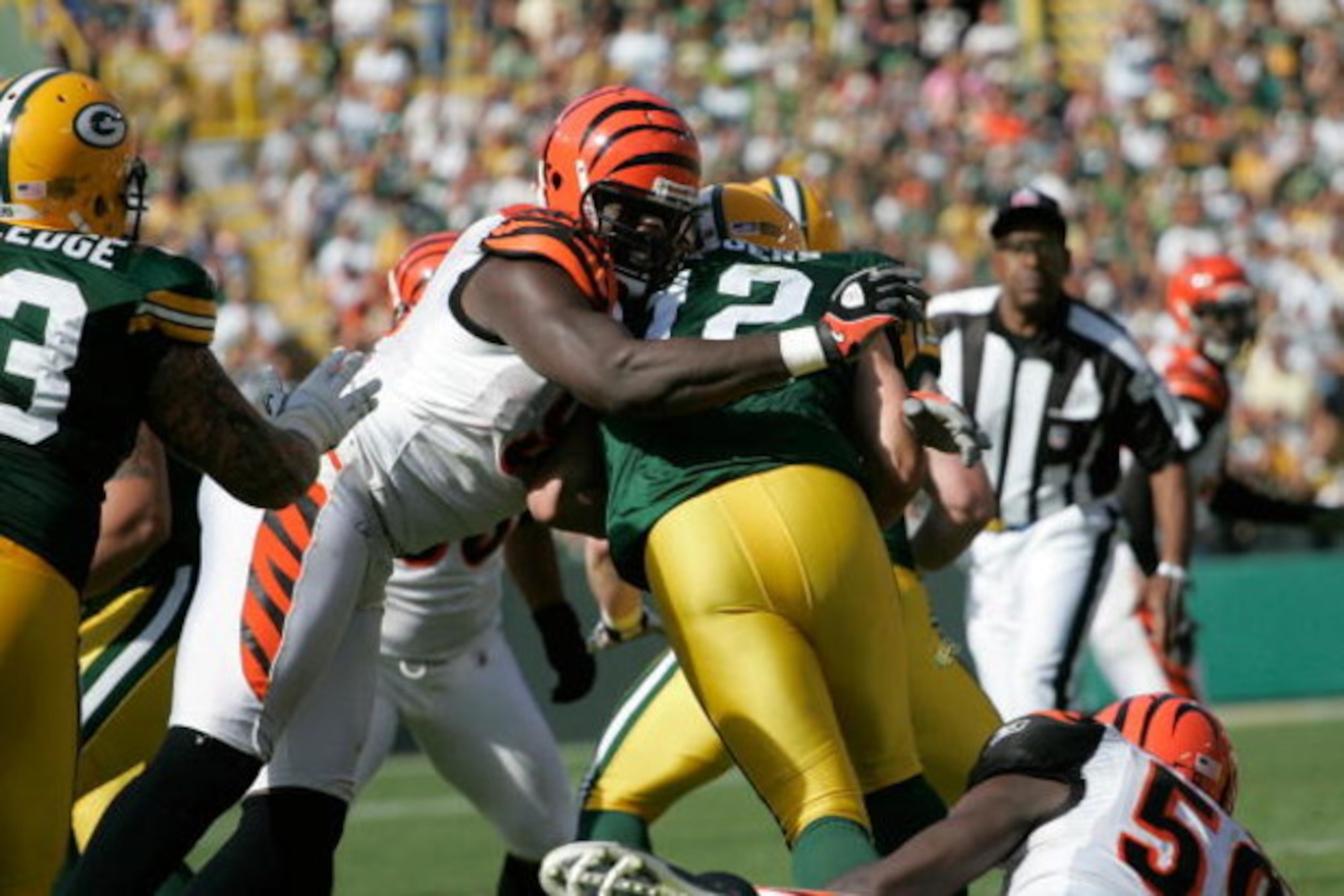 GREEN BAY, WI - SEPTEMBER 20: Quarterback Aaron Rogers #12 of the Green Bay Packers is sacked by defensive end Antwan Odem #98 of the Cincinnati Bengals at Lambeau Field on September 20, 2009 in Green Bay, Wisconsin. The Bengals defeated the Packers 31-24