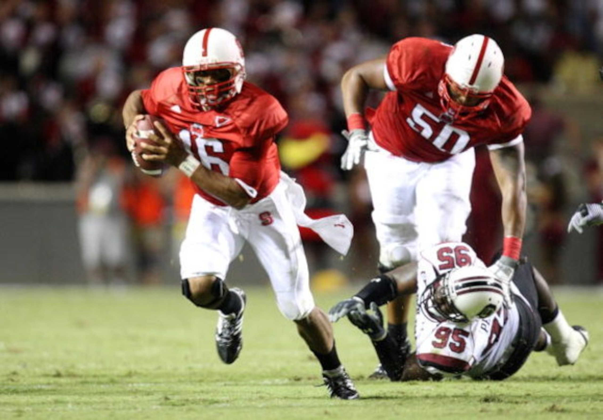 RALEIGH, NC - SEPTEMBER 3:  Quarterback Russell Wilson #16 of the North Carolina State Wolfpack scrambles for yards after avoiding the tackle by Nathan Pepper #95 of the South Carolina Gamecocks during the game at Carter-Finley Stadium on September 3, 200