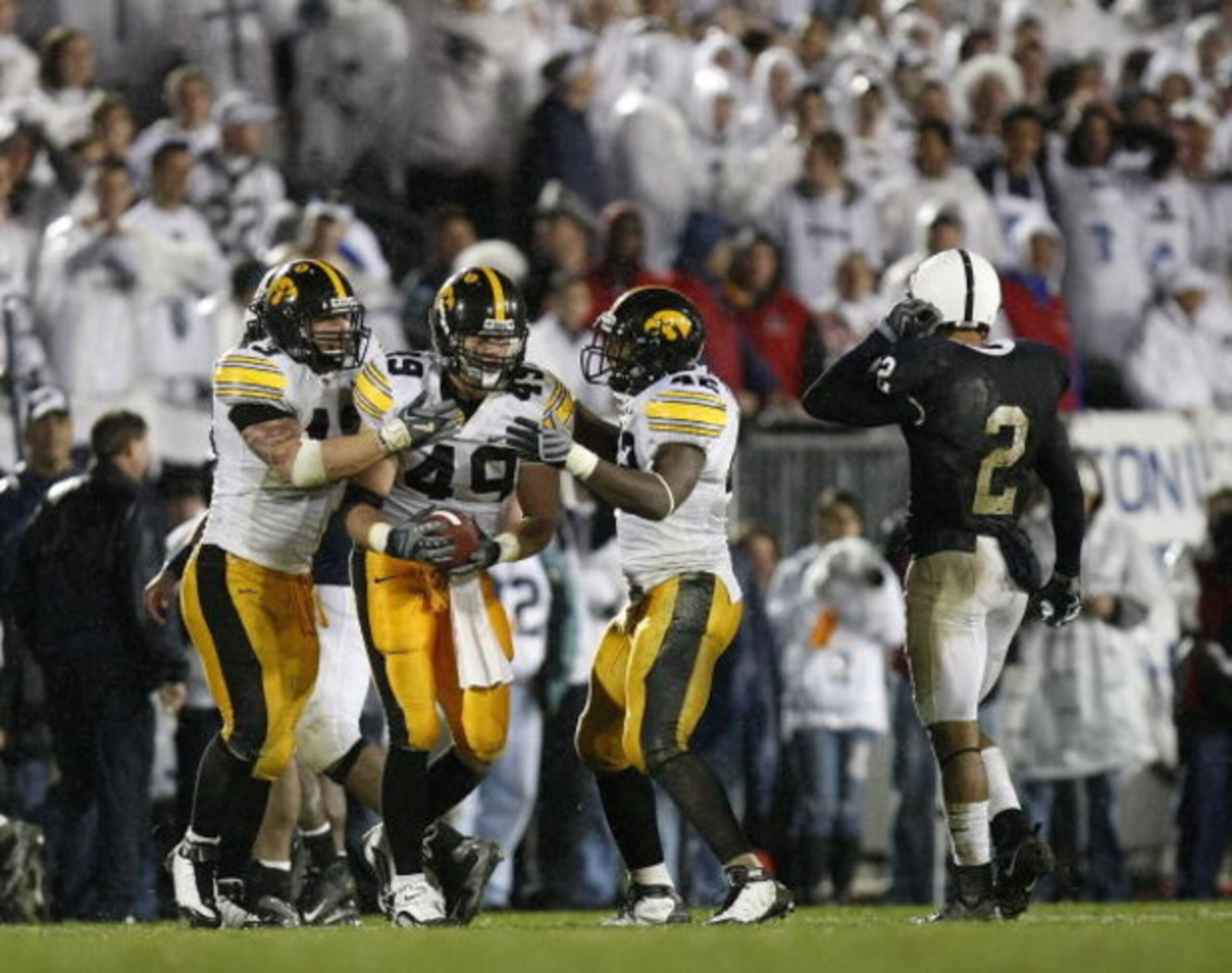 STATE COLLEGE, PA - SEPTEMBER 26:  A.J. Edds #49 of the Iowa Hawkeyes celebrates a fourth quarter interception with Pat Angerer #43 and Jeremiha Hunter #42 in front of Chaz Powell #2 of the Penn State Nittnay Lions  on September 26, 2009 at Beaver Stadium