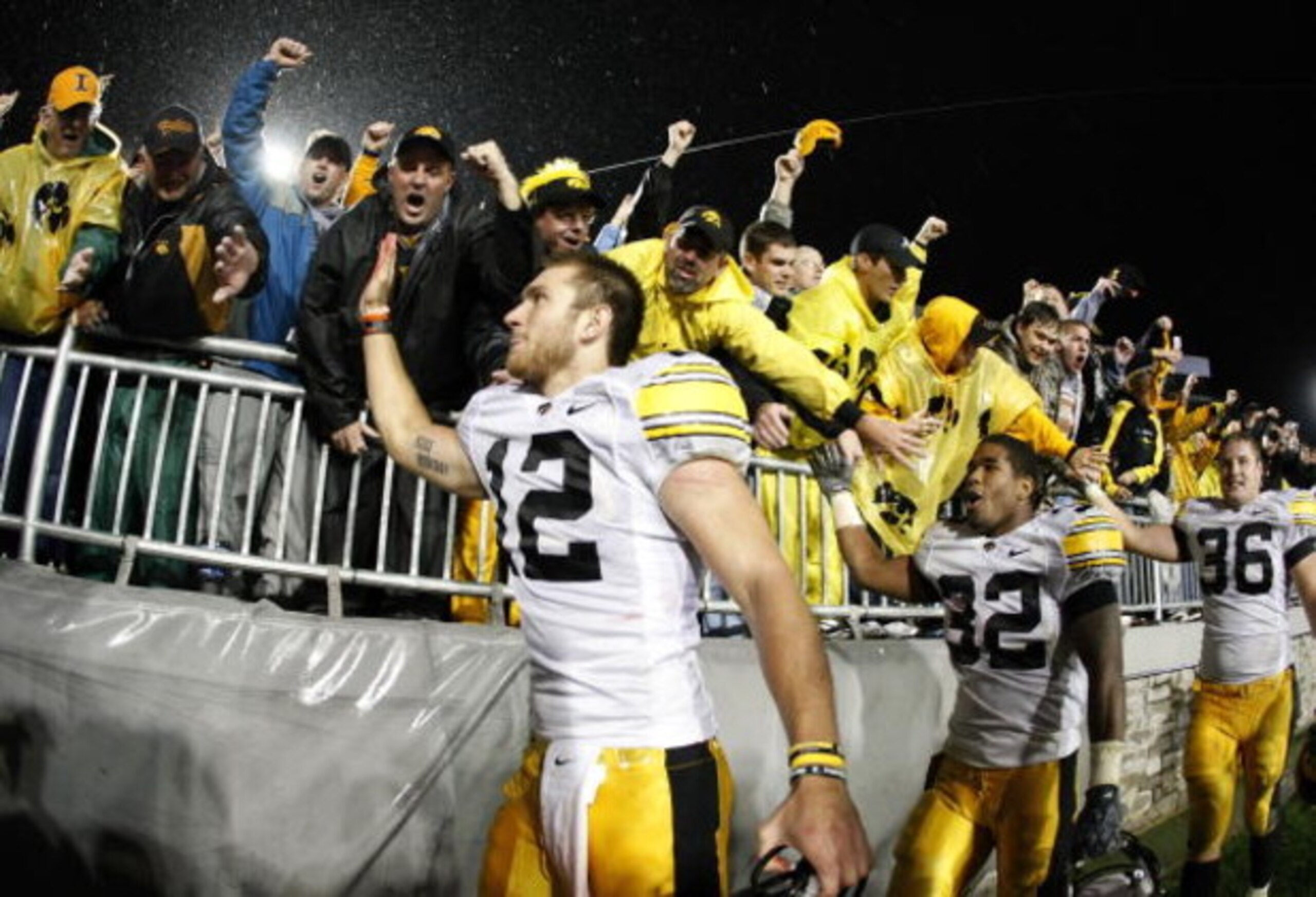 STATE COLLEGE, PA - SEPTEMBER 26:  Ricky Stanzi #12 of the Iowa Hawkeyes along with Adam Robinson #32 and Brett Morse #36 celebrate a 21-10 victory over the Penn State Nittnay Lions with Iowa fans on September 26, 2009 at Beaver Stadium in State College, 