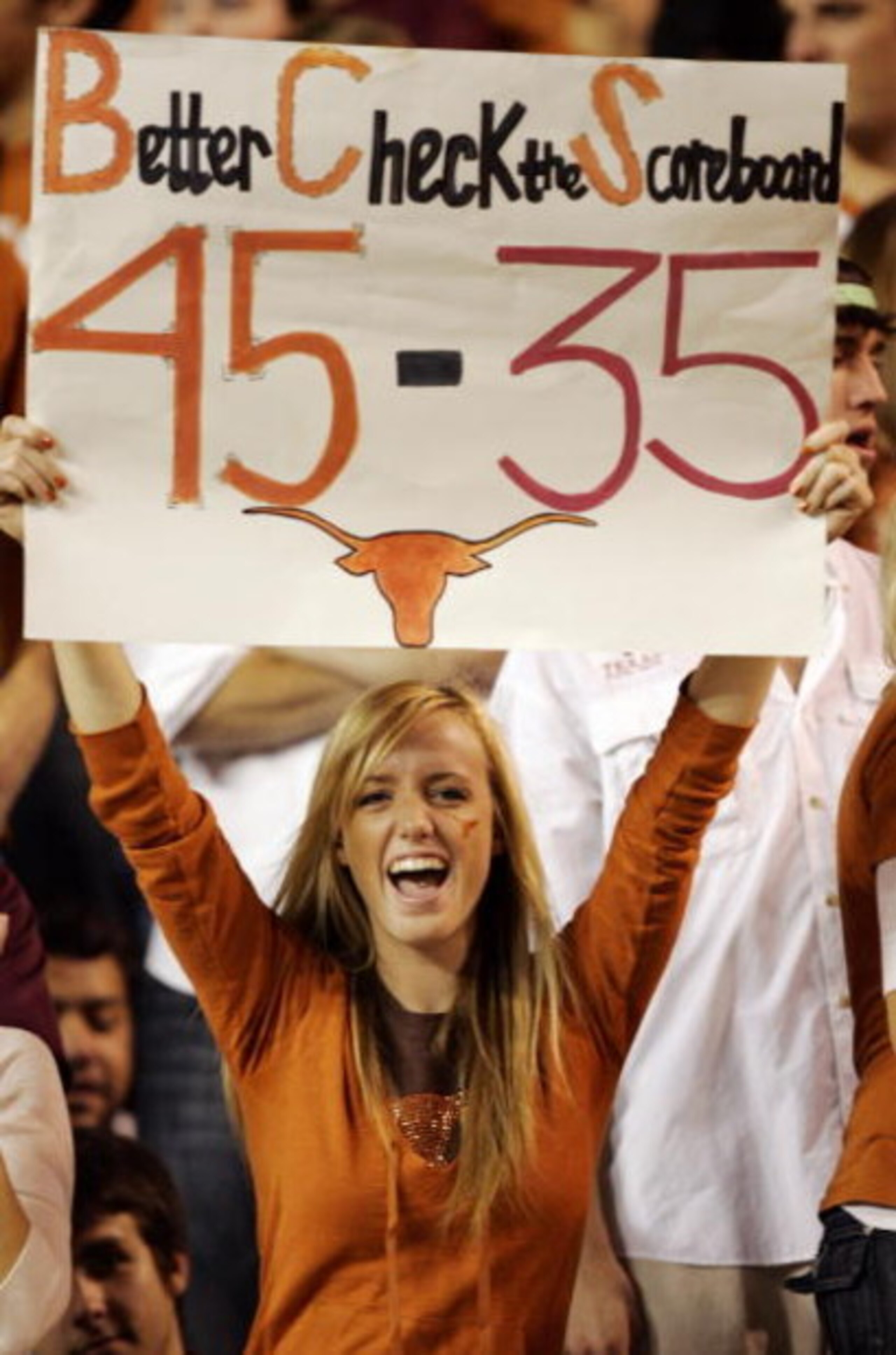 AUSTIN, TX - NOVEMBER 27:  A Texas Longhorn fan cheers on her team against the Texas A&M Aggies while holding a reminder of the Texas score against Oklahoma earlier in the season at Darrell K Royal-Texas Memorial Stadium November 27, 2008 in Austin, Texas