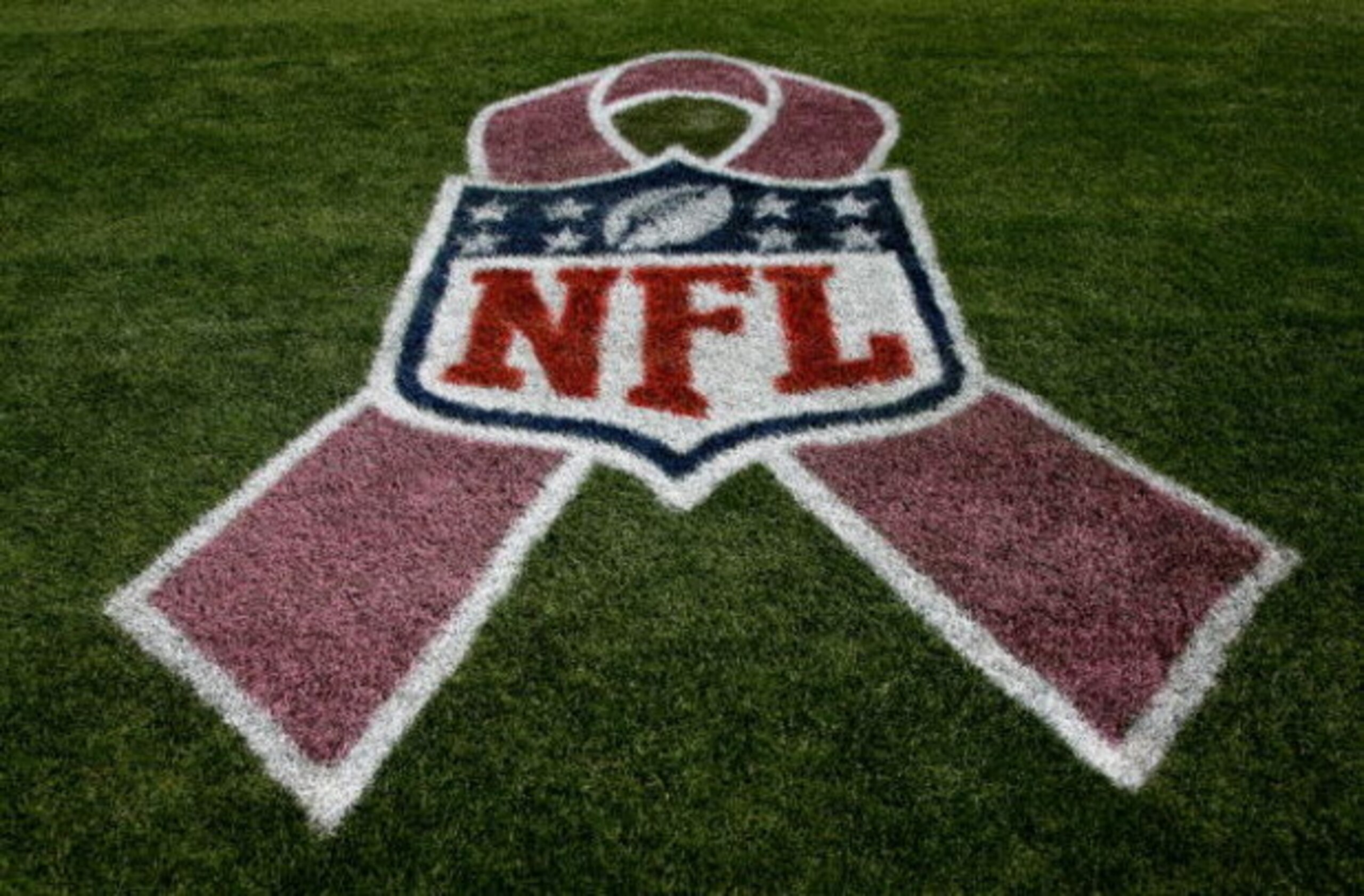 DENVER - OCTOBER 04:  The NFL logo is adorned with a pink ribbon on the sidelines as part of a program to raise awareness for breast cancer as the Dallas Cowboys face the Denver Broncos during NFL action at Invesco Field at Mile High on October 4, 2009 in