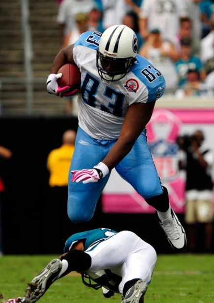 JACKSONVILLE, FL - OCTOBER 04:  Alge Crumpler #83 of the Tennessee Titans is tackled by Derek Cox #21 of the Jacksonville Jaguars at Jacksonville Municipal Stadium on October 4, 2009 in Jacksonville, Florida.  (Photo by Sam Greenwood/Getty Images)