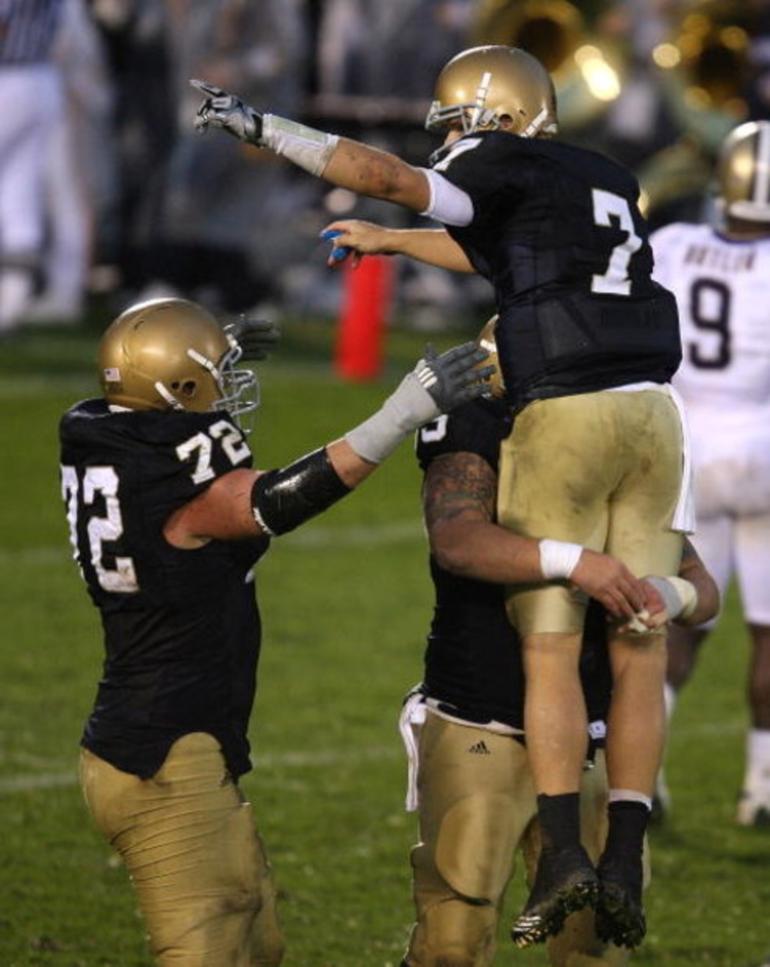 SOUTH BEND, IN - OCTOBER 03: Jimmy Clausen #7 of the Notre Dame Fighting Irish is lifted in the air by teammate Eric Olsen #55 as Paul Duncan #72 joins the celebration after a 4th quarter touchdown against the Washington Huskies on October 3, 2009 at Notr