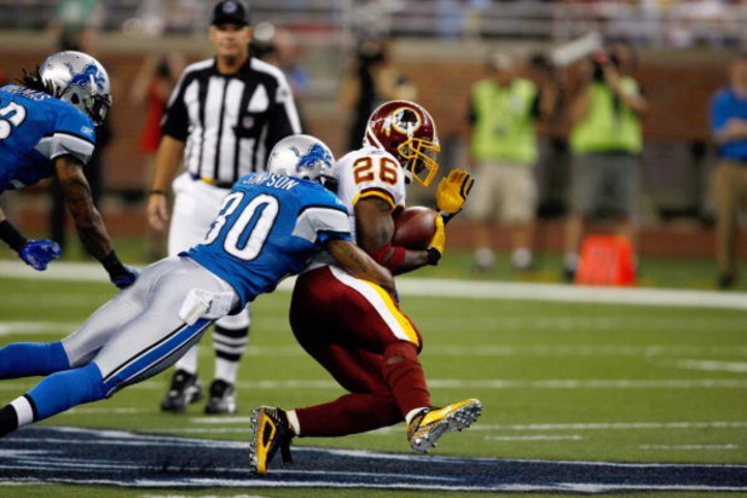 DETROIT, MI - SEPTEMBER 27: Running back Clinton Portis #26 of the Washington Redskins runs with the football as he is tackled by defensive back Ko Simpson #30 of the Detroit Lions at Ford Field on September 27, 2009 in Detroit, Michigan. The Lions defeat DETROIT, MI - SEPTEMBER 27: Running back Clinton Portis #26 of the Washington Redskins runs with the football as he is tackled by defensive back Ko Simpson #30 of the Detroit Lions at Ford Field on September 27, 2009 in Detroit, Michigan. The Lions defeat