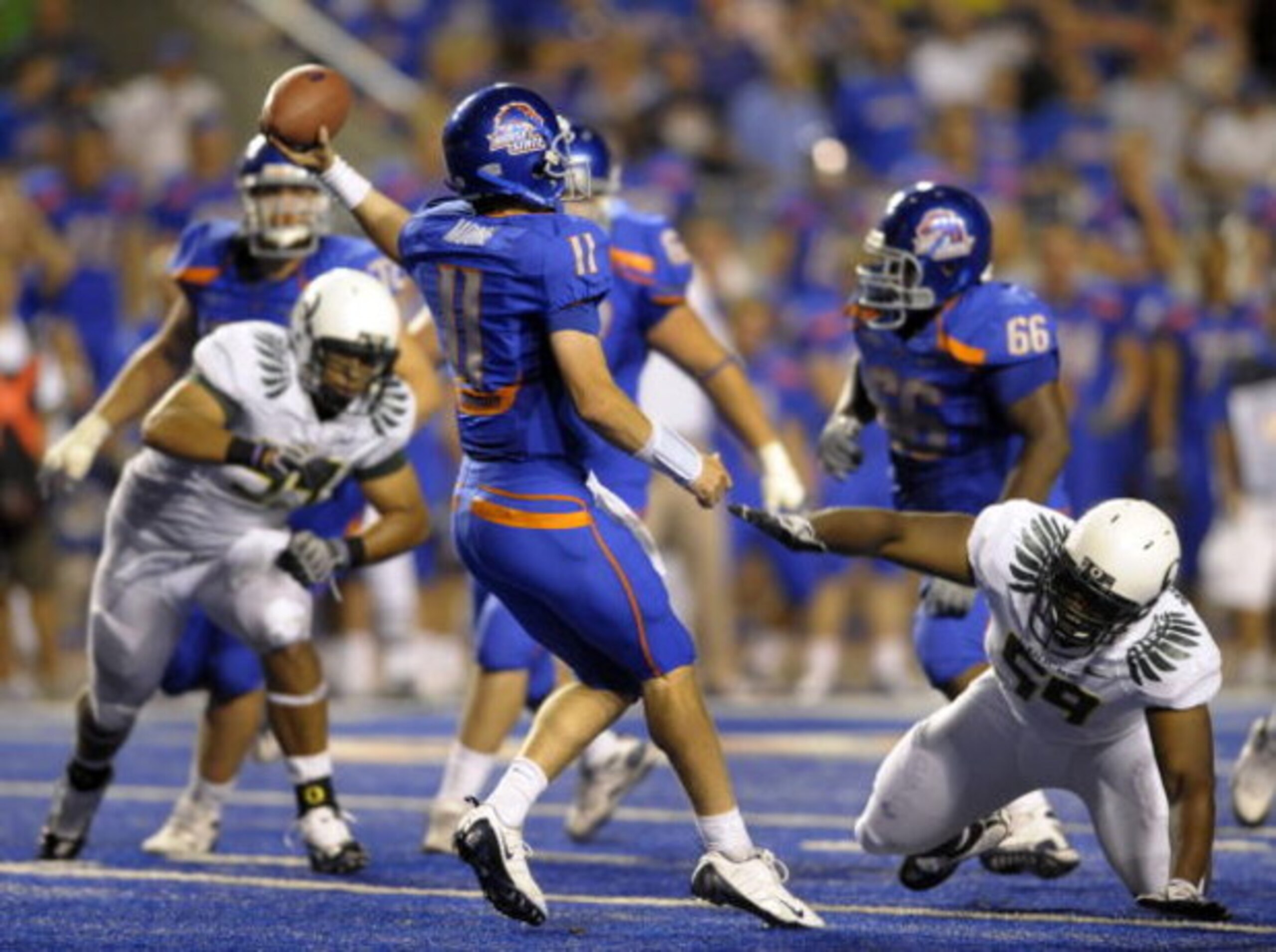 BOISE, ID - SEPTEMBER 3: Quarterback Kellen Moore #11 of the Boise State Broncos gets off a pass under the rush of Zac Clark #99 and Terrance Montgomery #59 of the Oregon Ducks in the fourth quarter of the game on September 3, 2009 at Bronco Stadium in Bo BOISE, ID - SEPTEMBER 3: Quarterback Kellen Moore #11 of the Boise State Broncos gets off a pass under the rush of Zac Clark #99 and Terrance Montgomery #59 of the Oregon Ducks in the fourth quarter of the game on September 3, 2009 at Bronco Stadium in Bo
