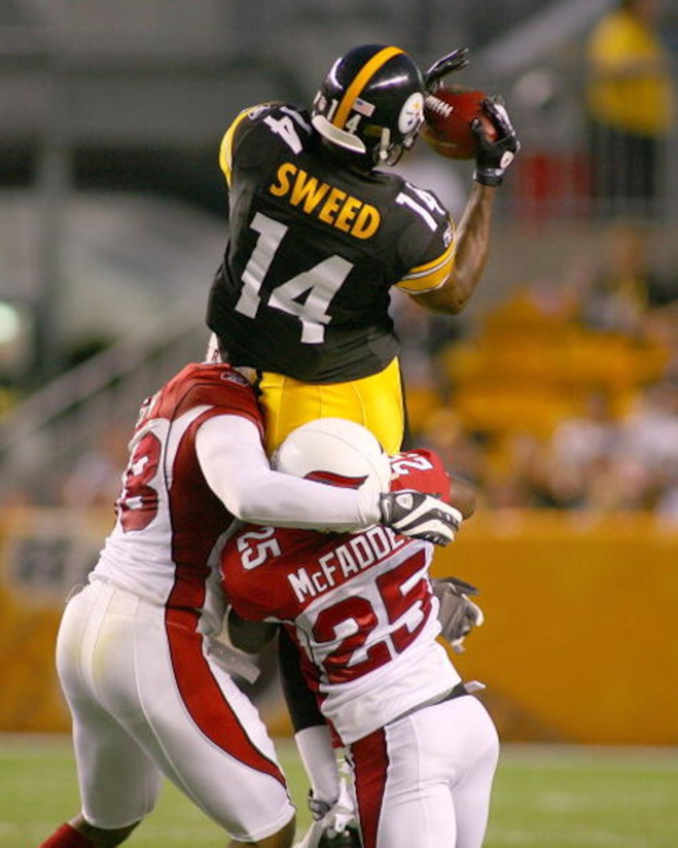 PITTSBURGH - AUGUST 13: Limas Sweed #14 of the Pittsburgh Steelers makes a catch as Karlos Dansby #58 and Bryant McFadden #25 of the Arizona Cardinals make the tackle during a preseason NFL game August 13, 2009 at Heinz Field in Pittsburgh, Pennsylvania. 