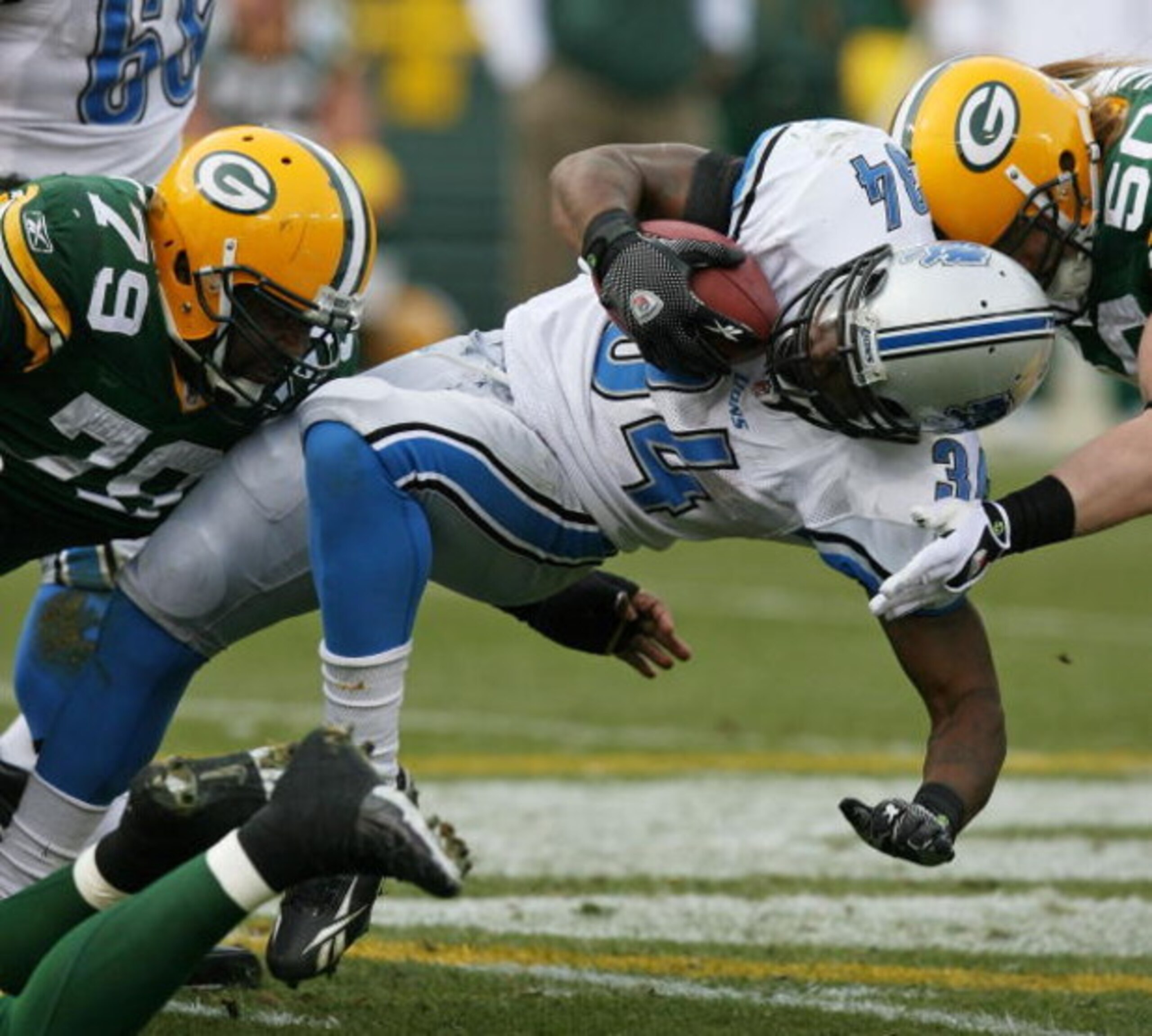 GREEN BAY, WI - OCTOBER 18: Kevin Smith #34 of the Detroit Lions is tackled by Ryan Pickett #79 and A.J. Hawk #50 of the Green Bay Packers at Lambeau Field on October 18, 2009 in Green Bay, Wisconsin. The Packers defeated the Lions 26-0. (Photo by Jonath GREEN BAY, WI - OCTOBER 18: Kevin Smith #34 of the Detroit Lions is tackled by Ryan Pickett #79 and A.J. Hawk #50 of the Green Bay Packers at Lambeau Field on October 18, 2009 in Green Bay, Wisconsin. The Packers defeated the Lions 26-0. (Photo by Jonath