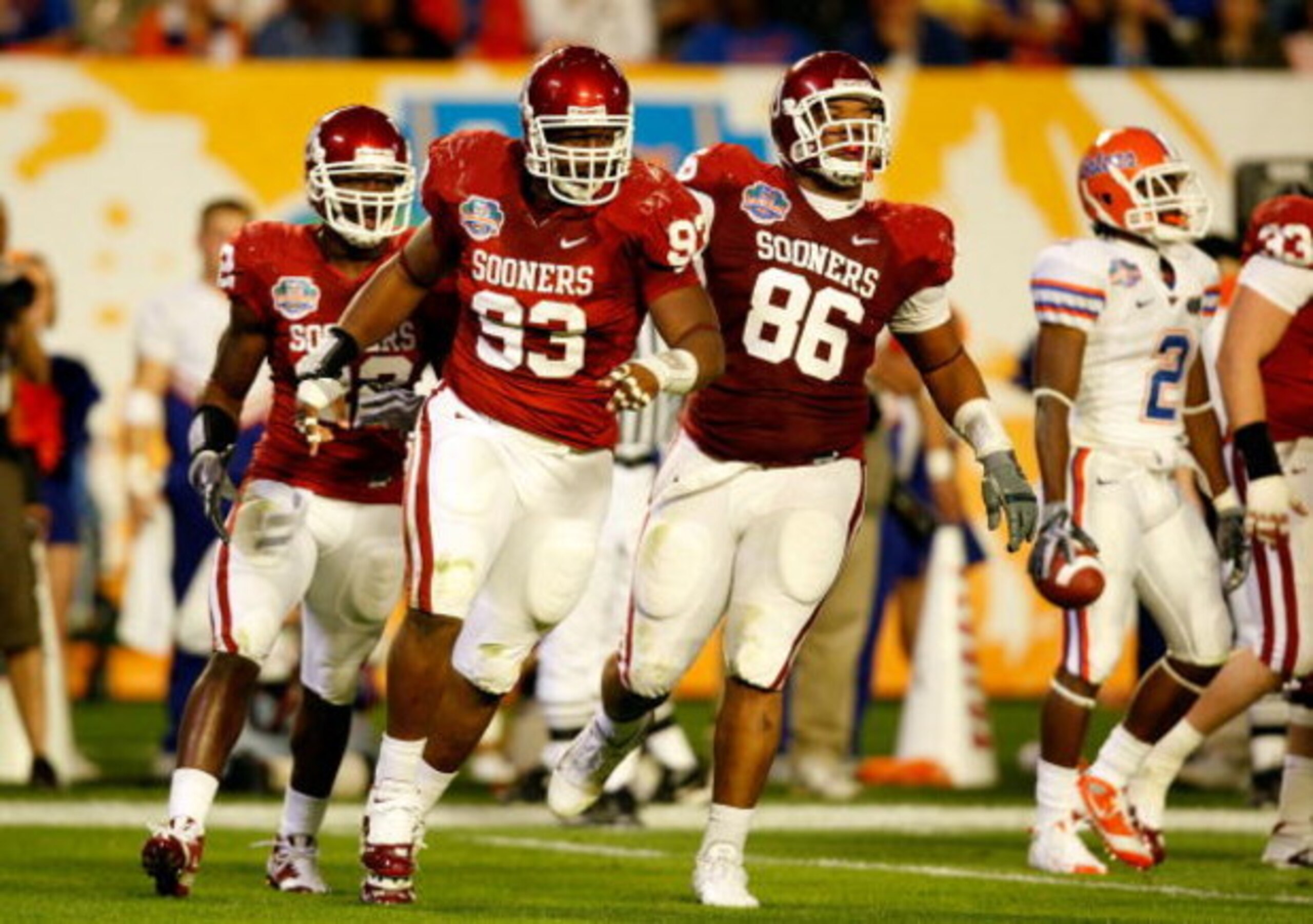 MIAMI - JANUARY 08:  (L-R) Keenan Calhoun #22, Gerald McCoy #93 and Adrian Taylor #86 of the Oklahoma Sooners celebrate a defensive stop against the Florida Gators during the FedEx BCS National Championship game at Dolphin Stadium on January 8, 2009 in Mi