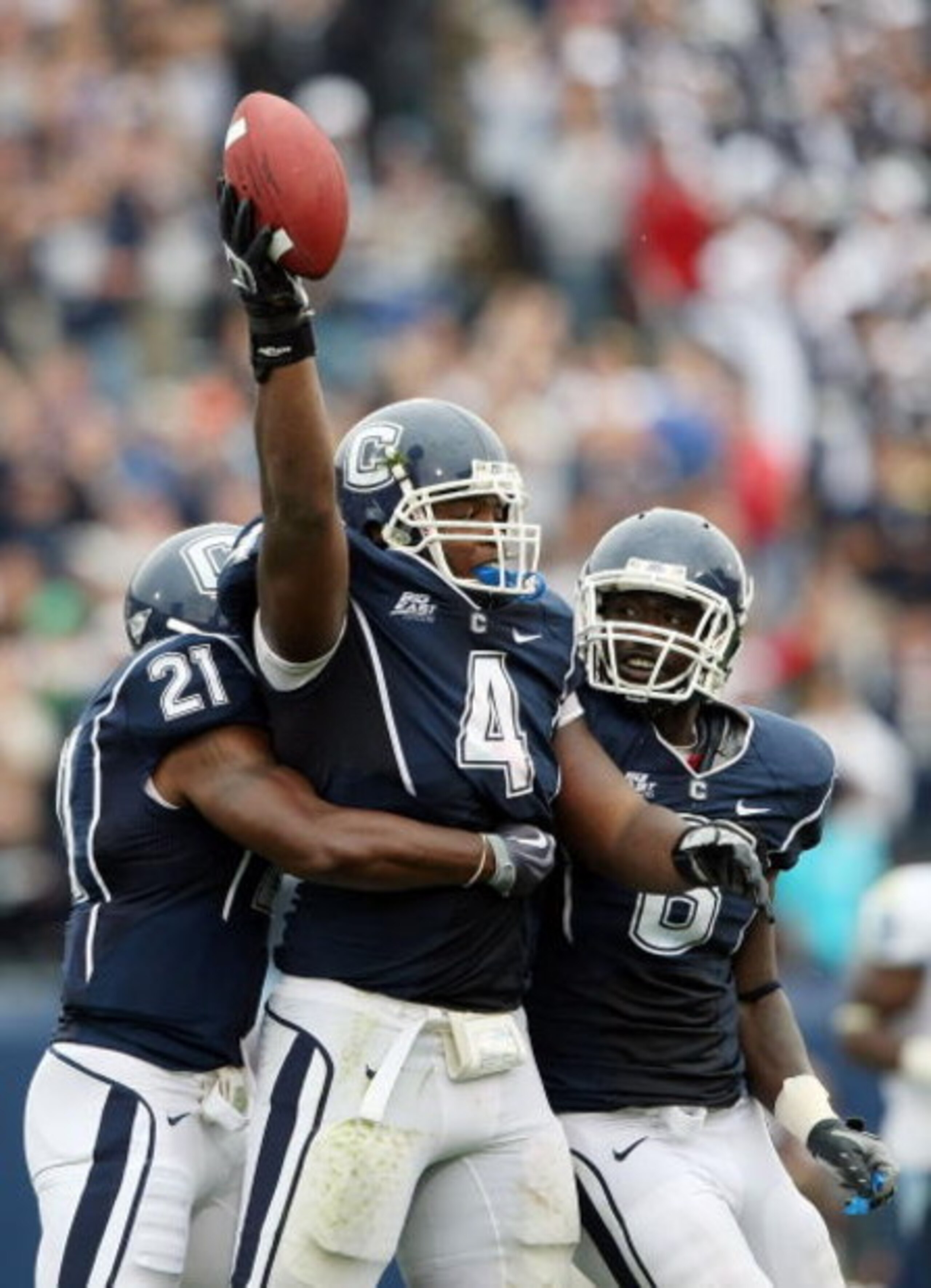 EAST HARTFORD, CT - SEPTEMBER 12:  Twyon Martin #4 of the Connecticut Huskies celebrates his fumble recovery with teammates Gary Wilburn #21 and Jasper Howard #6 in the second half against the North Carolinia Tar Heels on September 12, 2009 at Rentschler 