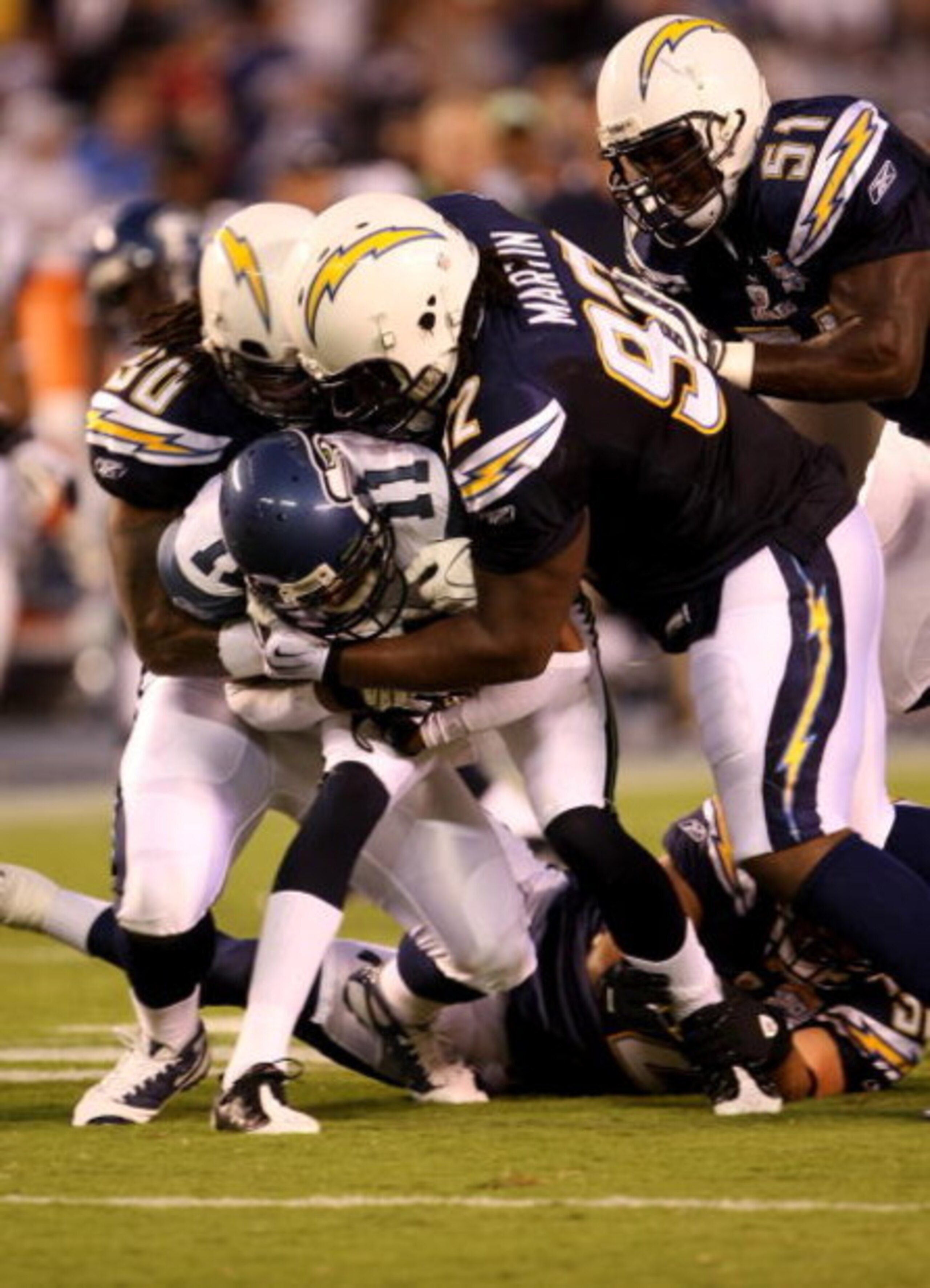 SAN DIEGO - AUGUST 15:  Linebacker Antwan Applewhite #90 and defensive end Vaughn Martin #92of the San Diego Chargers tackle receiver Deon Butler #11 of the Seattle Seahawks on August 15, 2009 at Qualcomm Stadium in San Diego, California.  (Photo by Steph