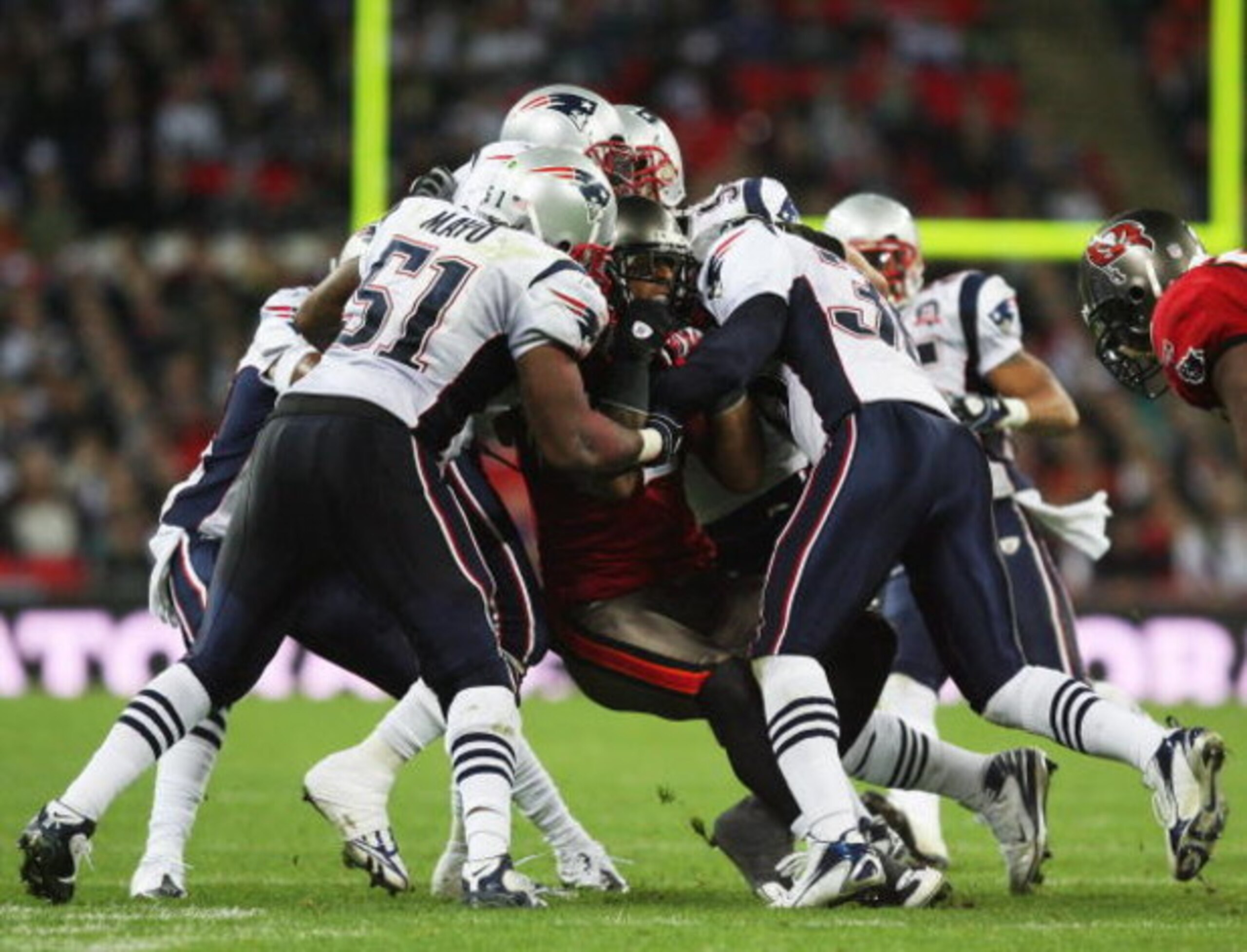 LONDON, ENGLAND - OCTOBER 25:  Kellen Winslow (#82)of Tampa Bay Buccaneers is tackled by the New England Patriots defence during the NFL International Series match between New England Patriots and Tampa Bay Buccaneers at Wembley Stadium on October 25, 200