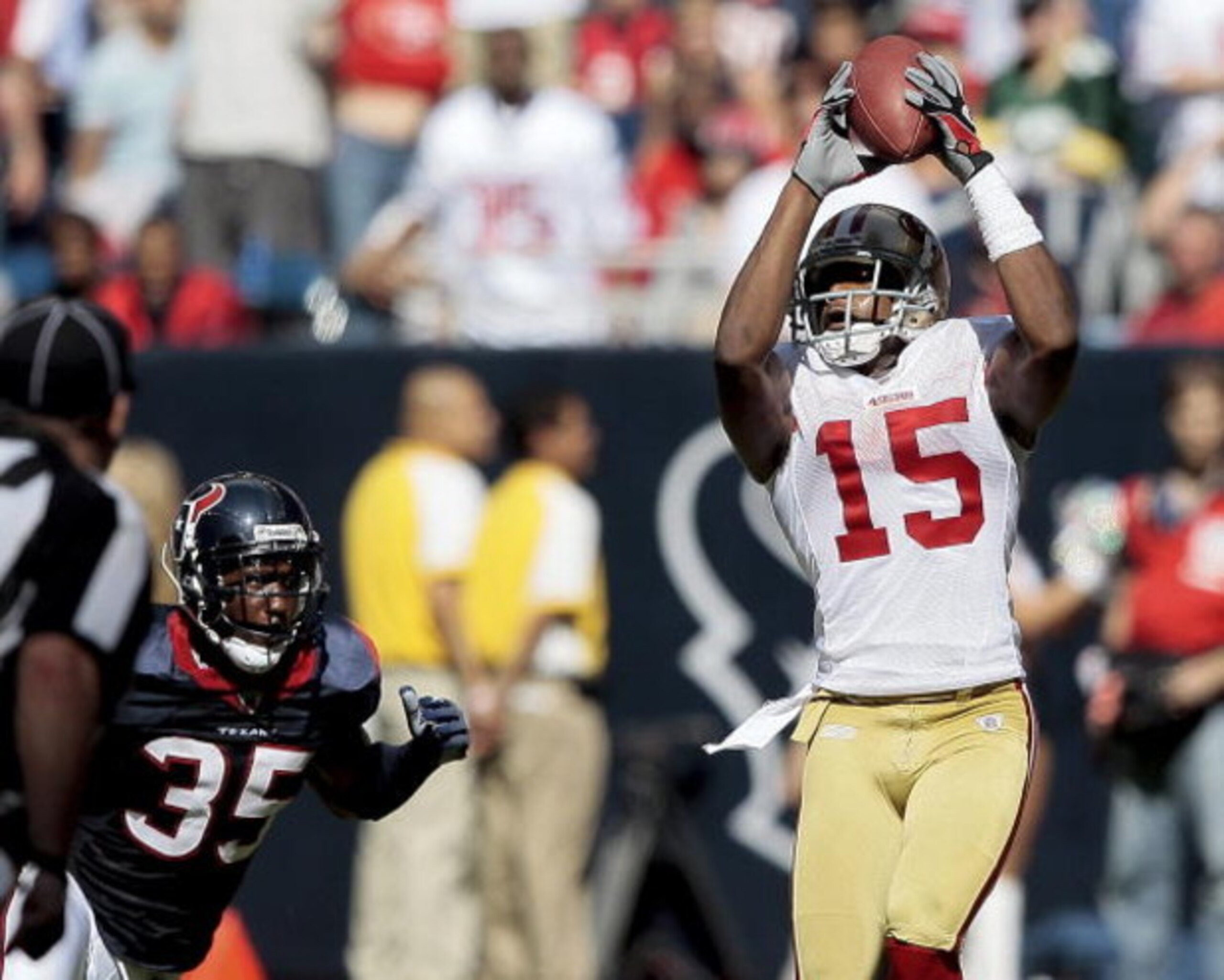 HOUSTON - OCTOBER 25:  Wide receiver Michael Crabtree #15 of the San Francisco 49ers catches a pass in the fourth quarter in front of cornerback Jacque Reeves #35 of the Houston Texans at Reliant Stadium on October 25, 2009 in Houston, Texas.  (Photo by B