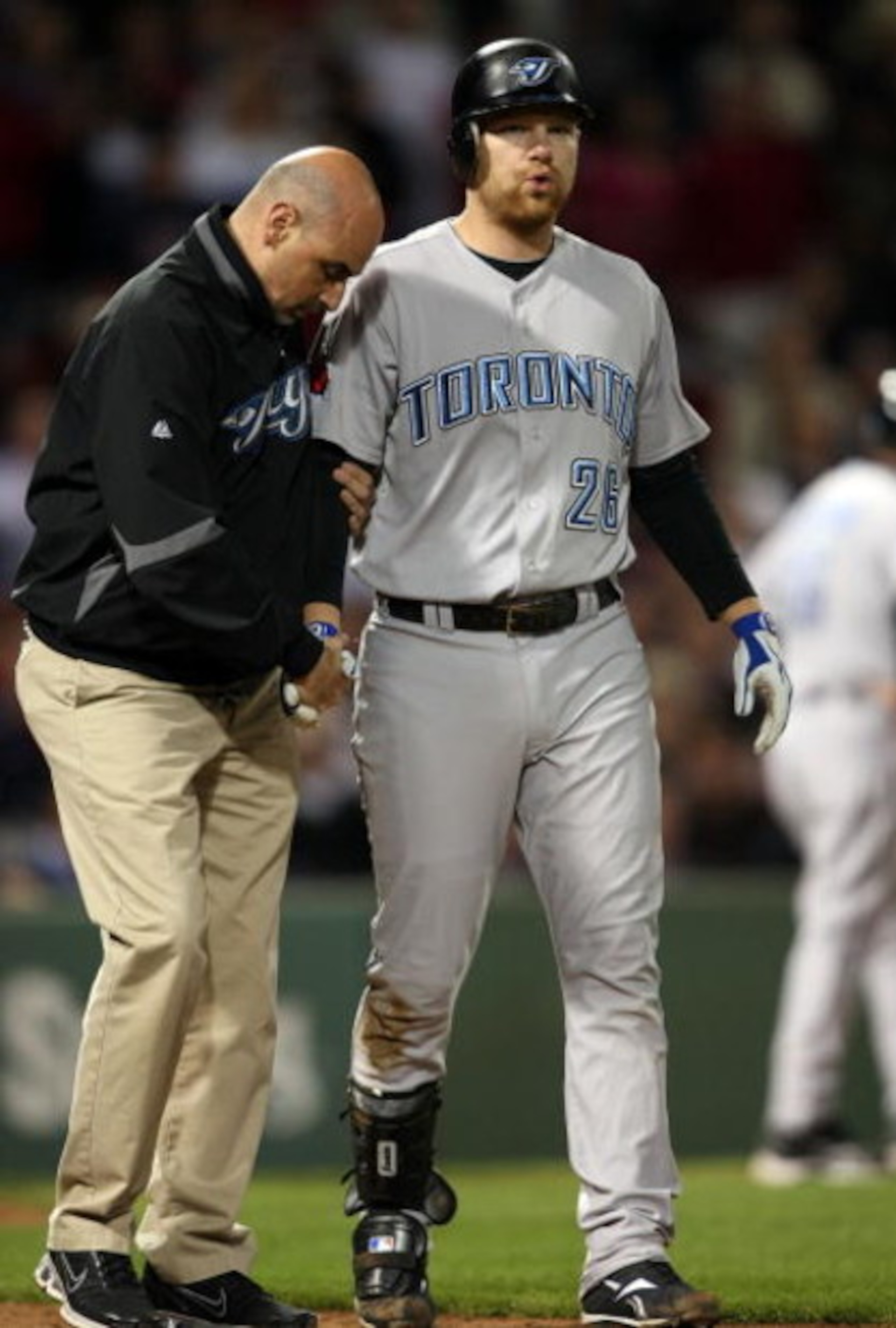 BOSTON - SEPTEMBER 29:  Adam Lind #26 of the Toronto Blue Jays is looked after by a member of the medical staff after he was hit by a pitch in the ninth inning against the Boston Red Sox on September 29, 2009 at Fenway Park in Boston, Massachusetts. The B
