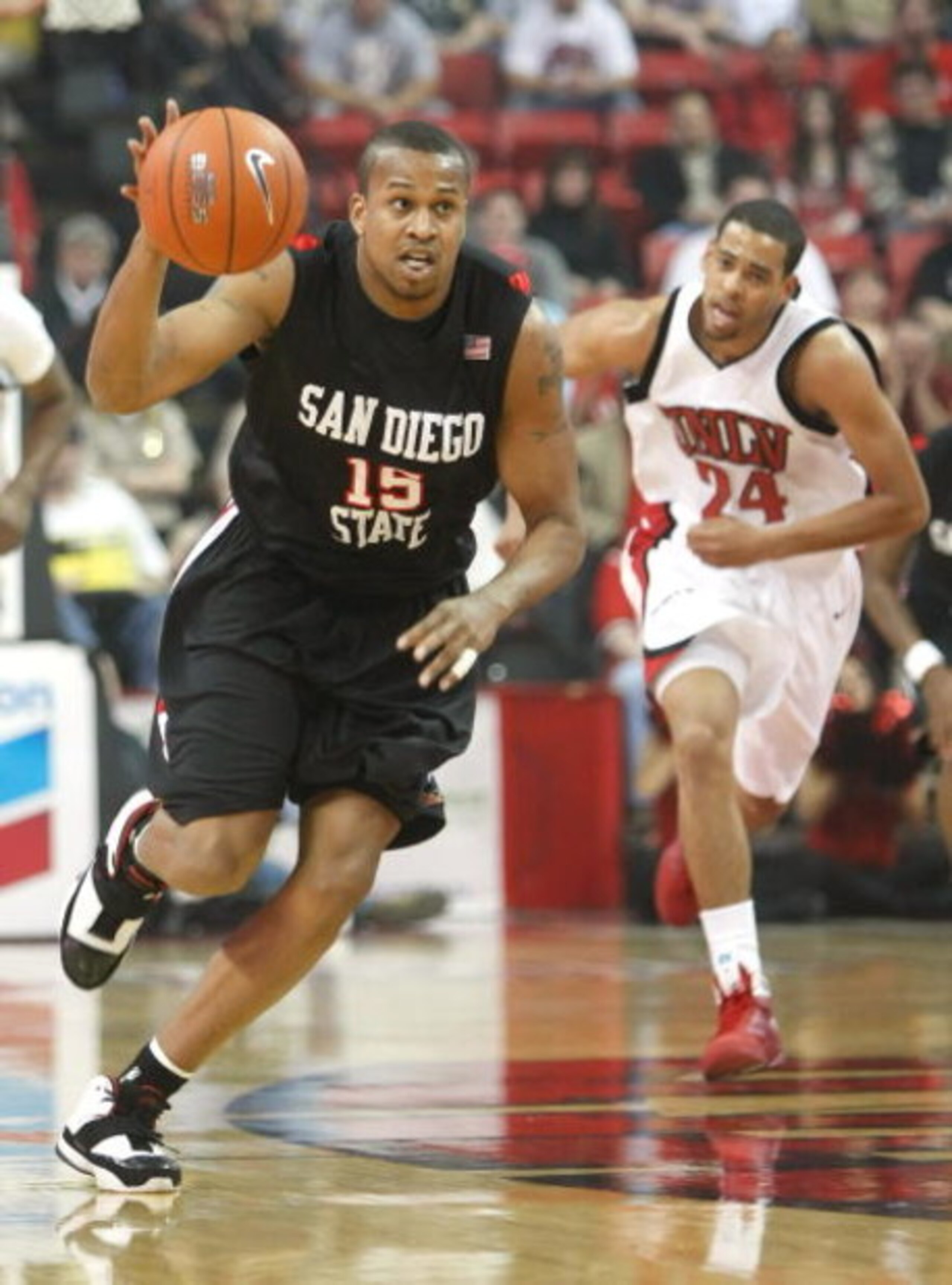 LAS VEGAS - FEBRUARY 03:  Kyle Spain #15 of the San Diego State Aztecs goes on a fast break ahead of Rene Rougeau #24 of the UNLV Rebels during the first half of their game at the Thomas & Mack Center February 3, 2009 in Las Vegas, Nevada. The Aztecs won 