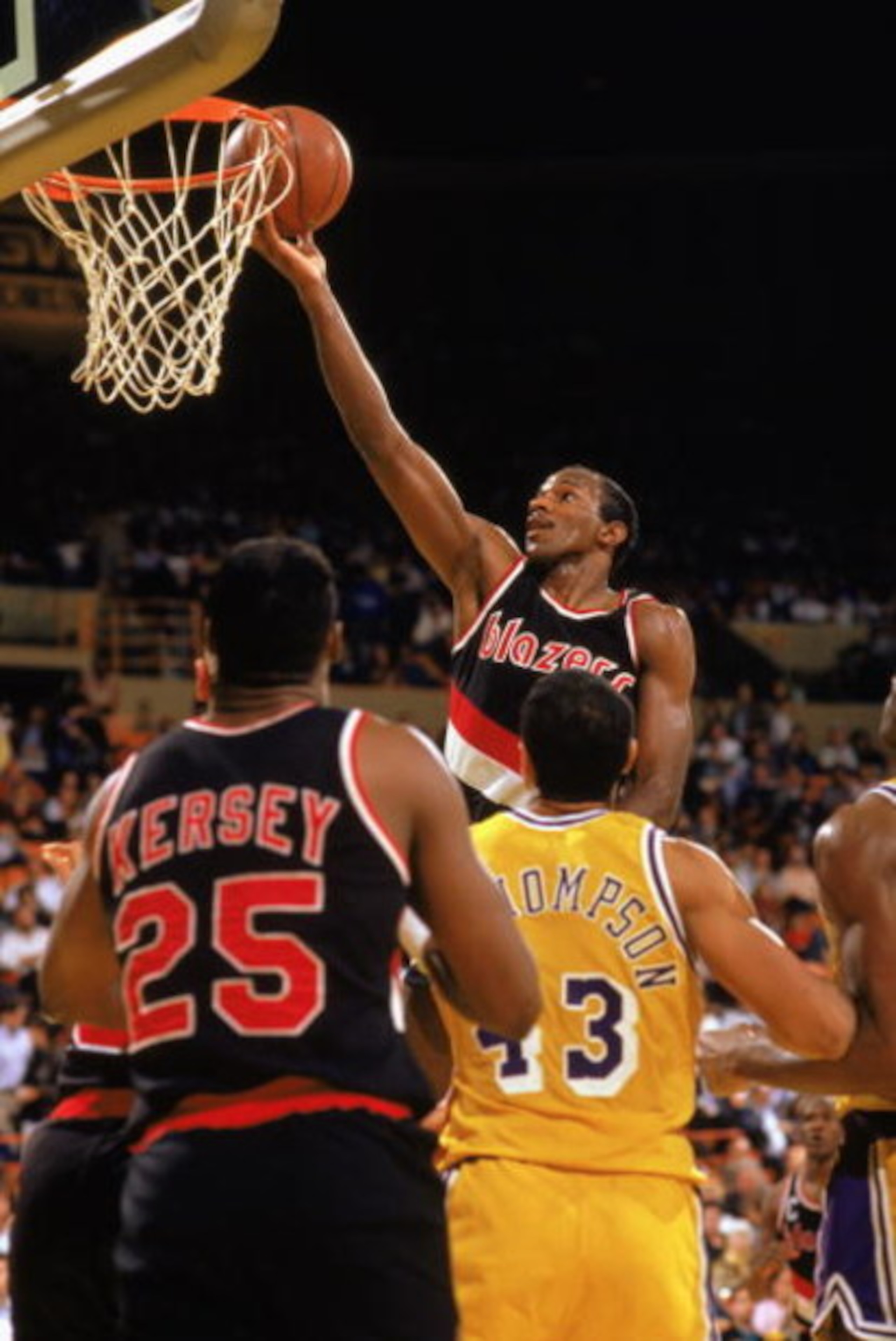 LOS ANGELES - 1989:  Clyde Drexler #22 of the Portland Trail Blazers shoots a layup past Mychal Thompson #43 of the Los Angeles Lakers during the 1988-1989 NBA season game at the Great Westen Forum in Los Angeles, California.  (Photo by Tim DeFrisco/Getty
