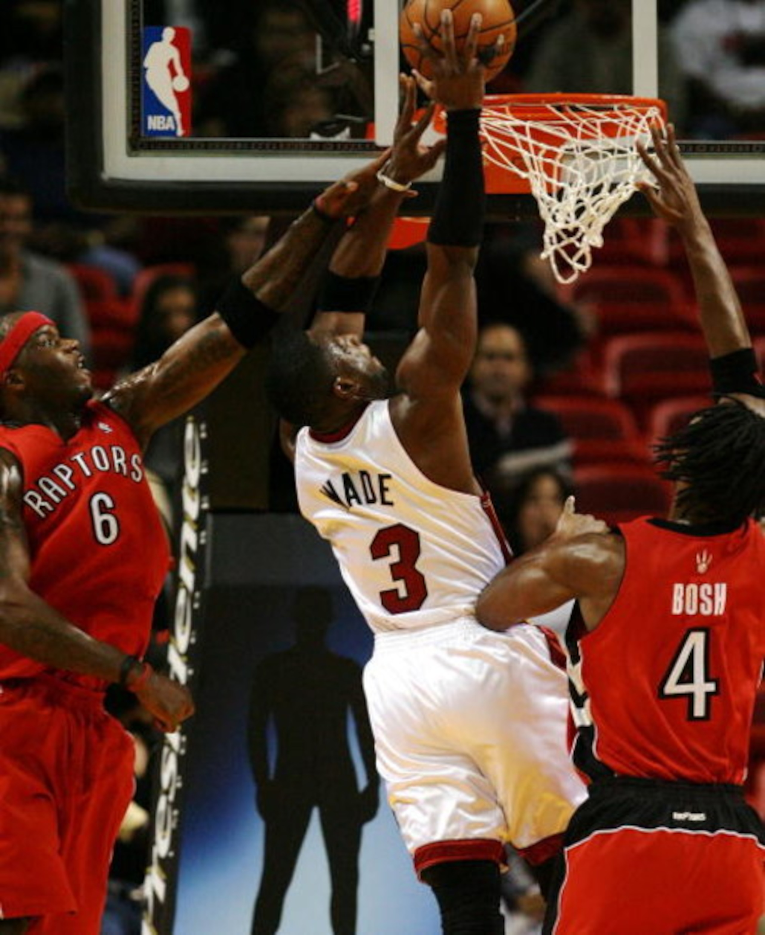 MIAMI - NOVEMBER 19:  Dwyane Wade #3 of the Miami Heat dunks over Chris Bosh #4 and Jermaine O'Neal #6 of the Toronto Raptors at American Airlines Arena on November 19, 2008 in Miami, Florida. The Raptors defeated the Heat 101-95. NOTE TO USER: User expre