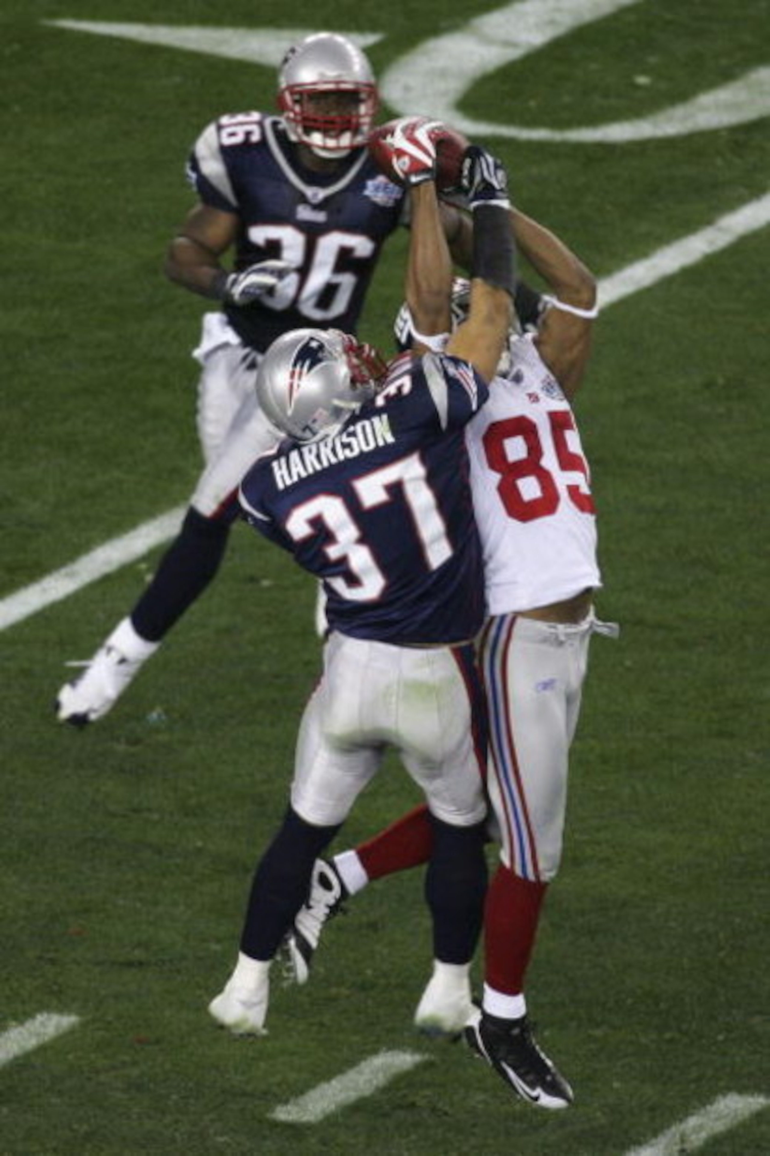 GLENDALE, AZ - FEBRUARY 03:  David Tyree #85 of the New York Giants catches a 32-yard pass from Eli Manning #10 as Rodney Harrison #37 of the New England Patriots attempts to knock it out in the fourth quarter of Super Bowl XLII on February 3, 2008 at the