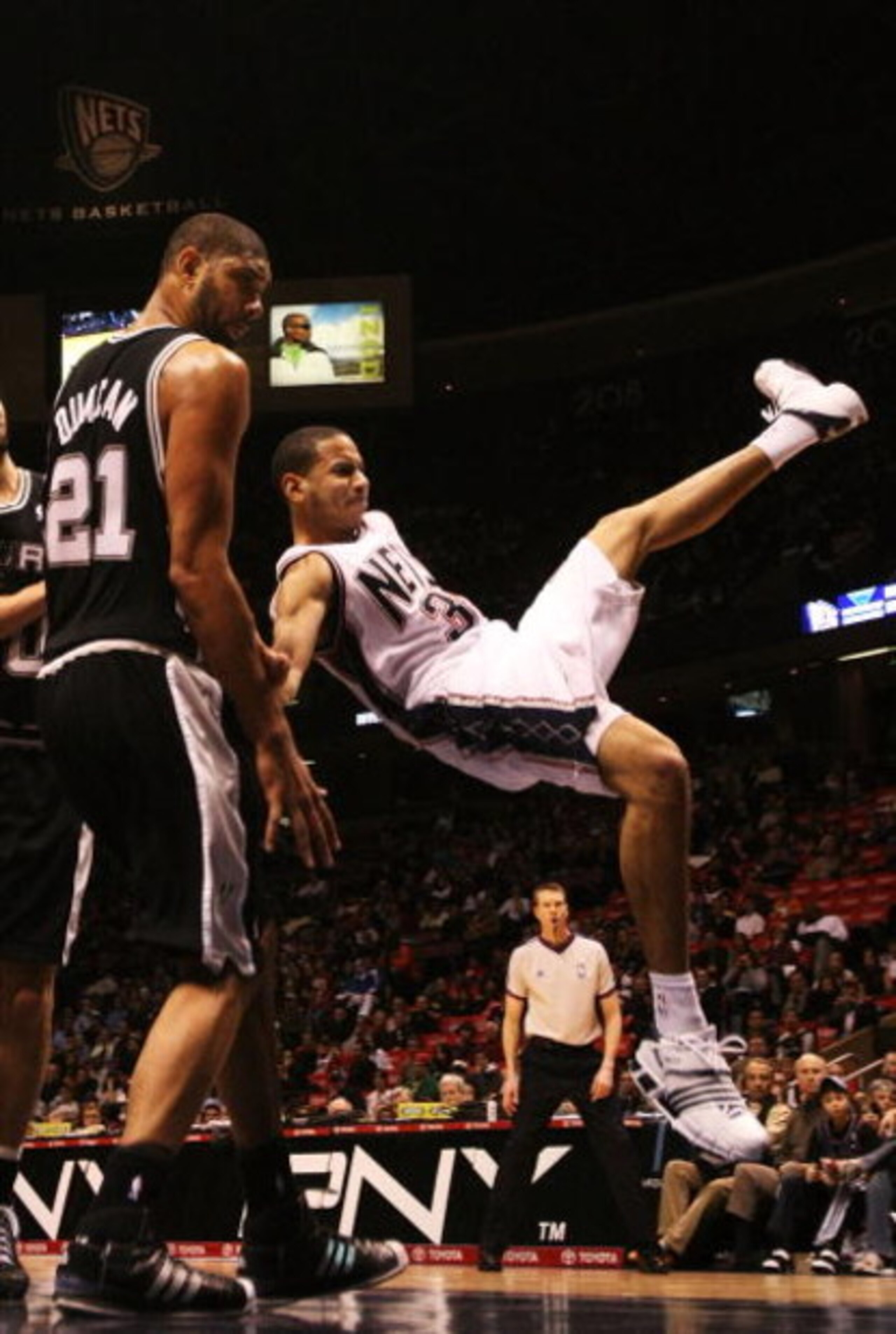 EAST RUTHERFORD, NJ - MARCH 02:  Devin Harris #34 of the New Jersey Nets is fouled by Tim Duncan #21 of the San Antonio Spurs during their game on March 2, 2008 at the Izod Arena in East Rutherford, New Jersey.  NOTE TO USER: User expressly acknowledges a