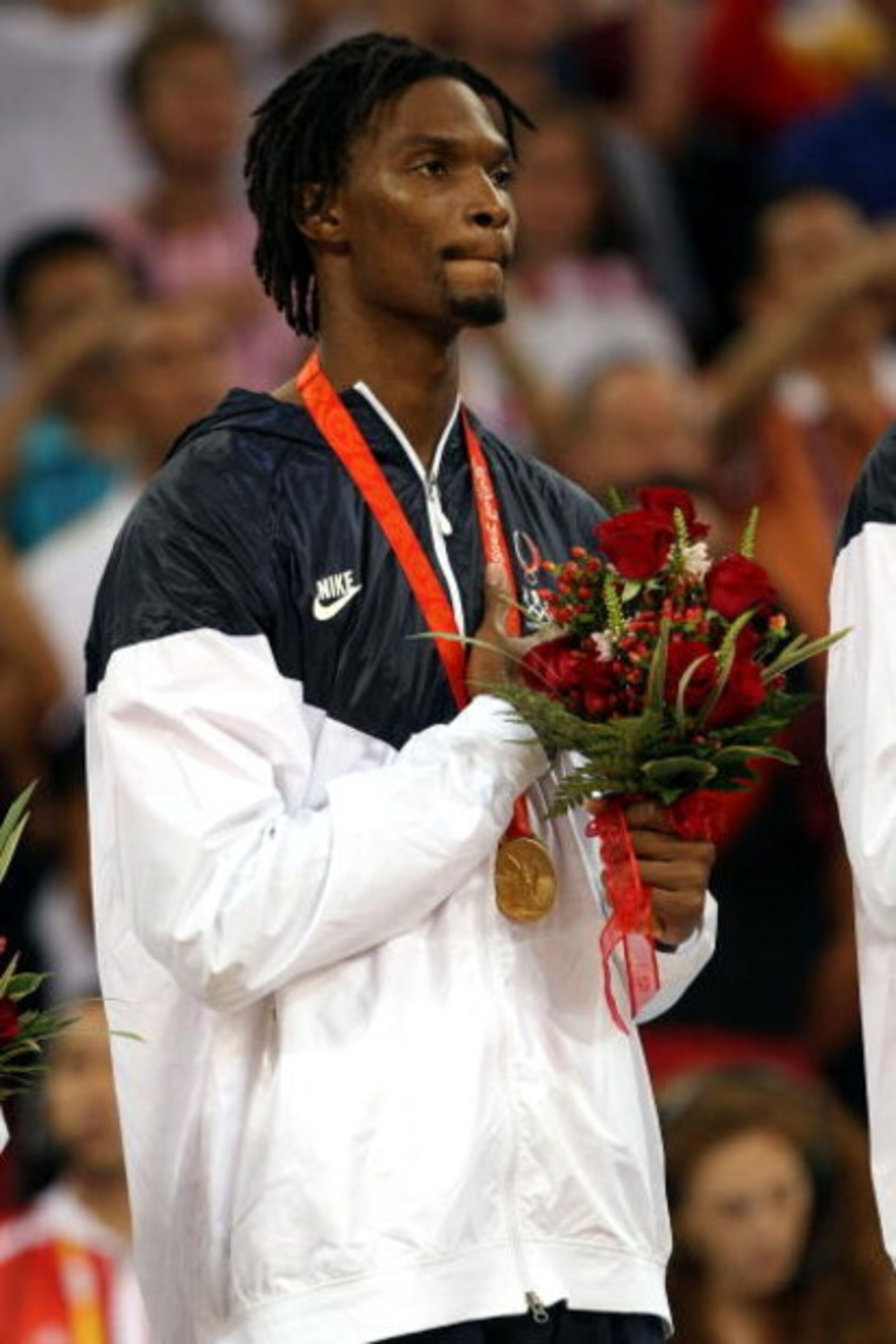 BEIJING - AUGUST 24:  Chris Bosh #12 of the United States salutes as his countries National Anthem is played during the medal ceremony after defeating Spain 118-107 in the gold medal game during Day 16 of the Beijing 2008 Olympic Games at the Beijing Olym