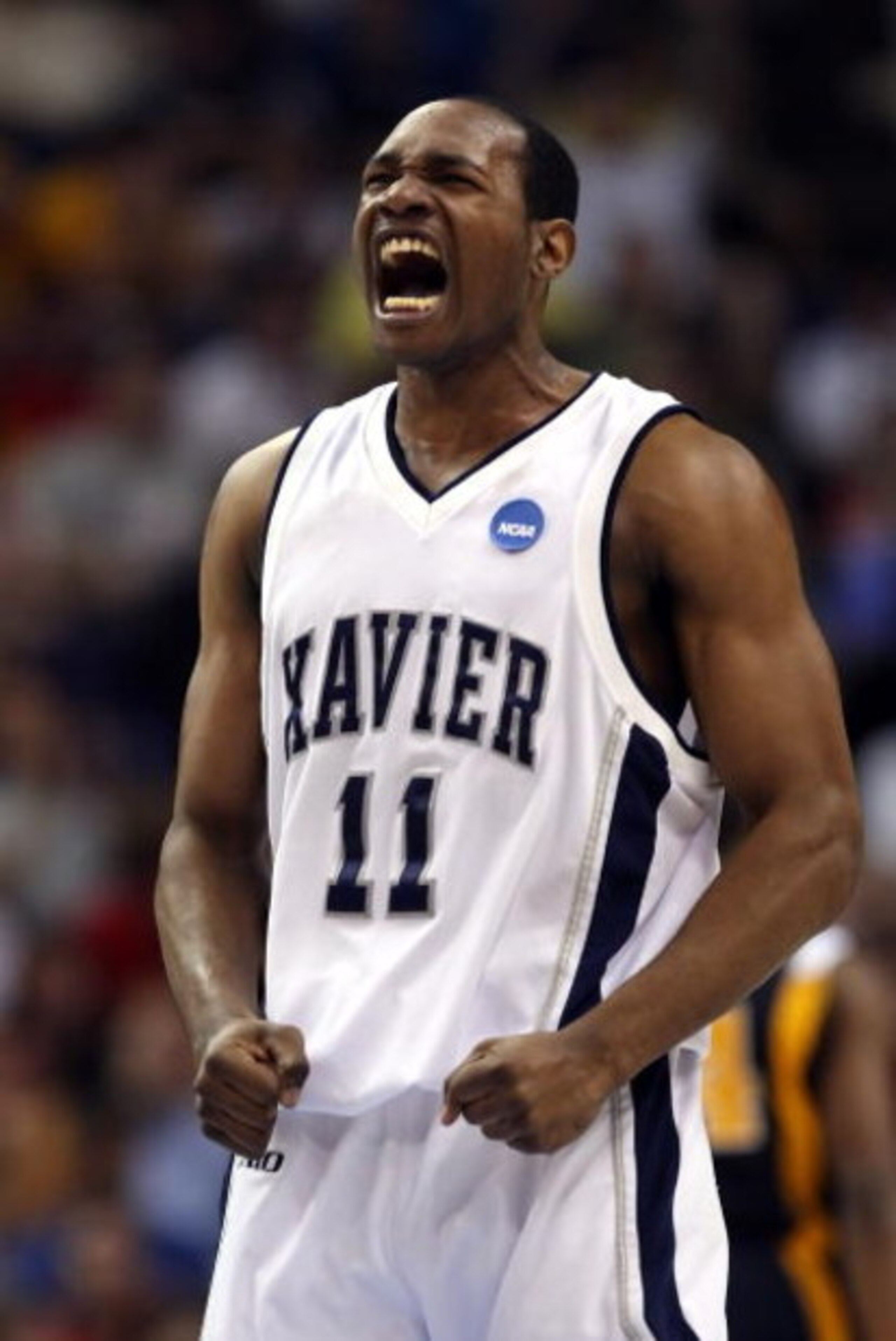 PHOENIX - MARCH 27:  B.J. Raymond #11 of the Xavier Musketeers celebrates a three pointer in the final minutes of overtime during the West Regional Sweet 16 game against West Virginia Mountaineers at the U.S. Airways Center on March 27, 2008 in Phoenix, A