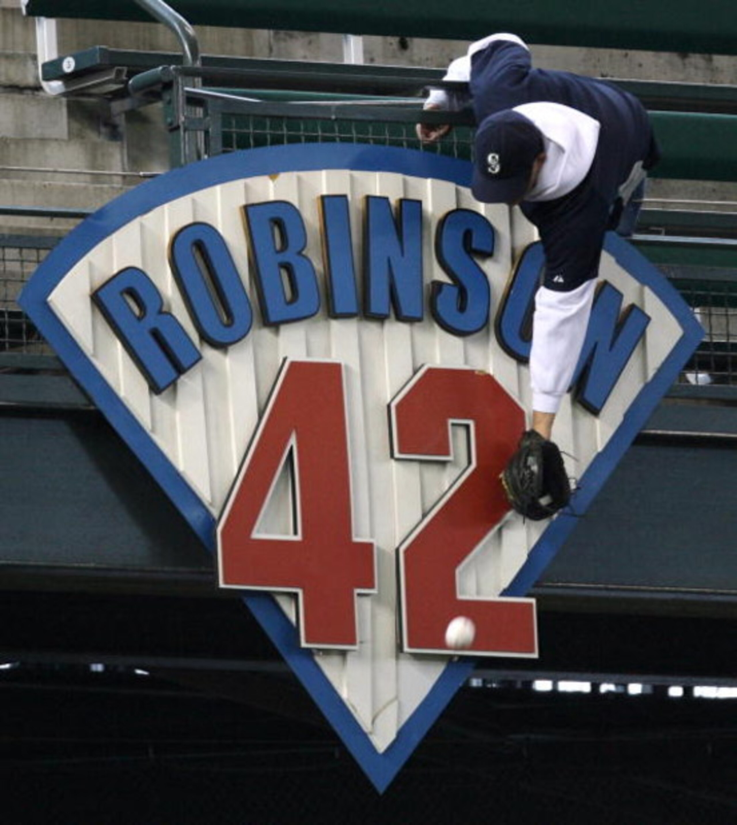 SEATTLE - APRIL 15:  A fan reaches over the Jackie Robinson plaque for a home run ball hit during batting practice prior to the game between the Seattle Mariners and Kansas City Royals on April 15, 2008 at Safeco Field in Seattle, Washington. (Photo by Ot