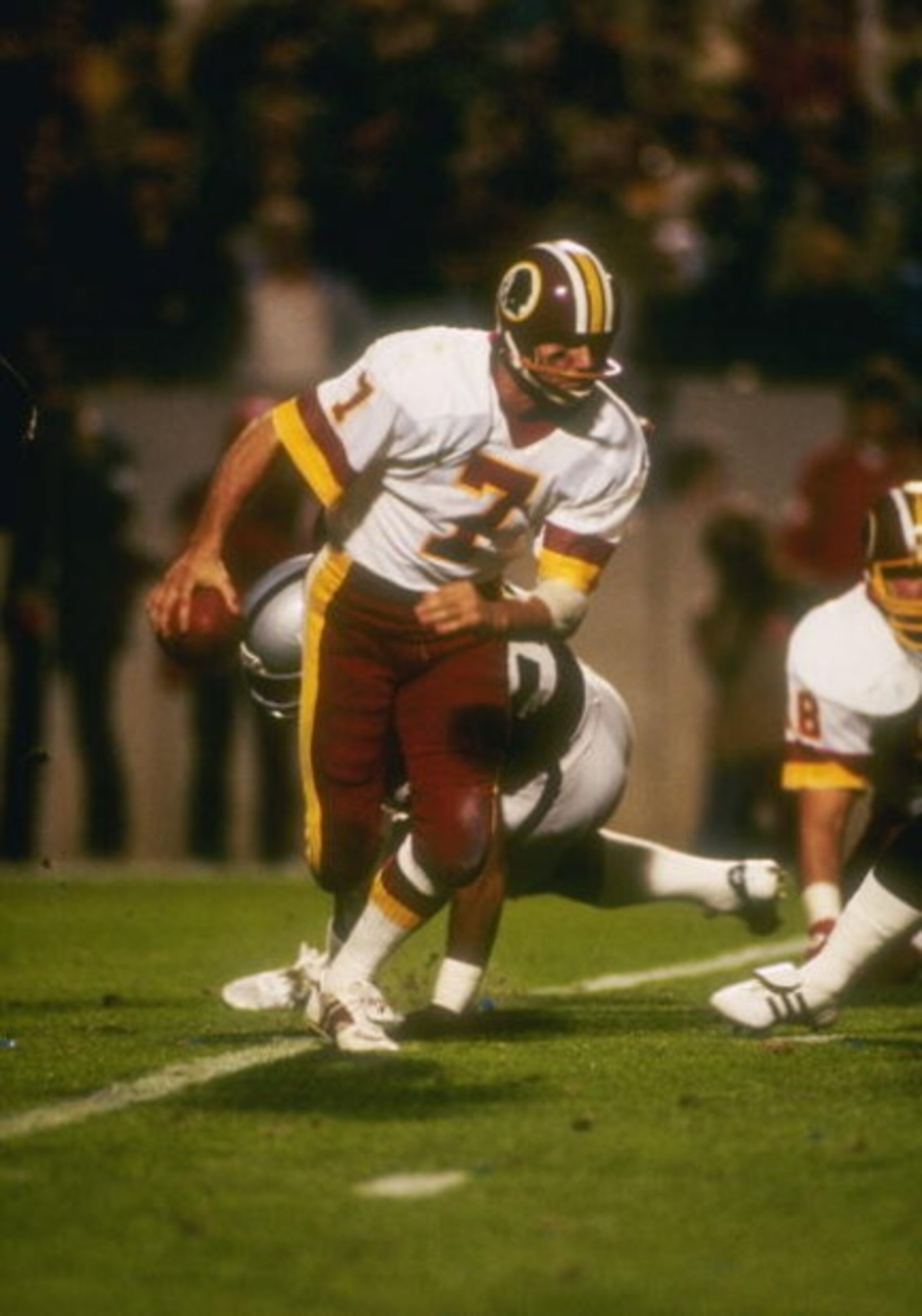 22  Jan 1984:  Quarterback Joe Theismann  #7 of the Washington Redskins charges off with the ball during Super Bowl XVIII against the Los Angeles Raiders at Tampa Stadium in Tampa, Florida.The Raiders won the game, 38-9. Mandatory Credit: Allsport  /Allsp