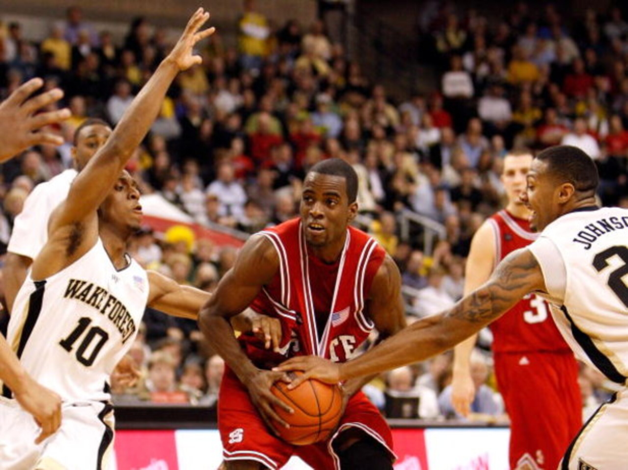 WINSTON-SALEM, NC - FEBRUARY 26:  Farnold Degand #12 of the North Carolina State Wolfpack collides with teammates Ishmael Smith #10 and James Johnson #23 of the Wake Forest Demon Deacons during their game at Lawrence Joel Coliseum on February 26, 2009 in 