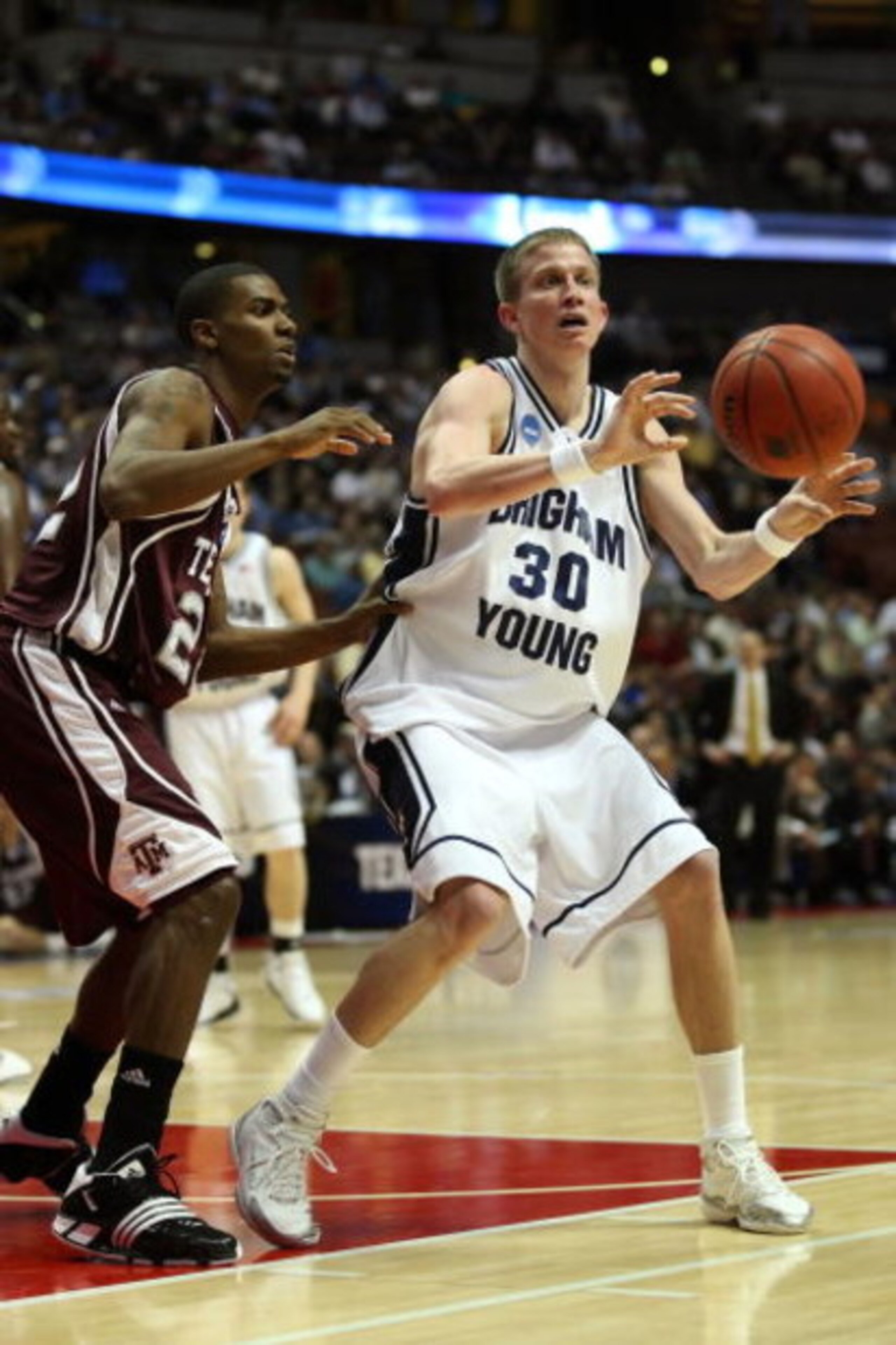 ANAHEIM, CA - MARCH 20:  Lee Cummard #30 of the Brigham Young Cougars looks to pass over the defense of Dominique Kirk #22 of the Texas A&M Aggies during the West Region first round of the NCAA Basketball Tournament at the Honda Center on March 20, 2008 i