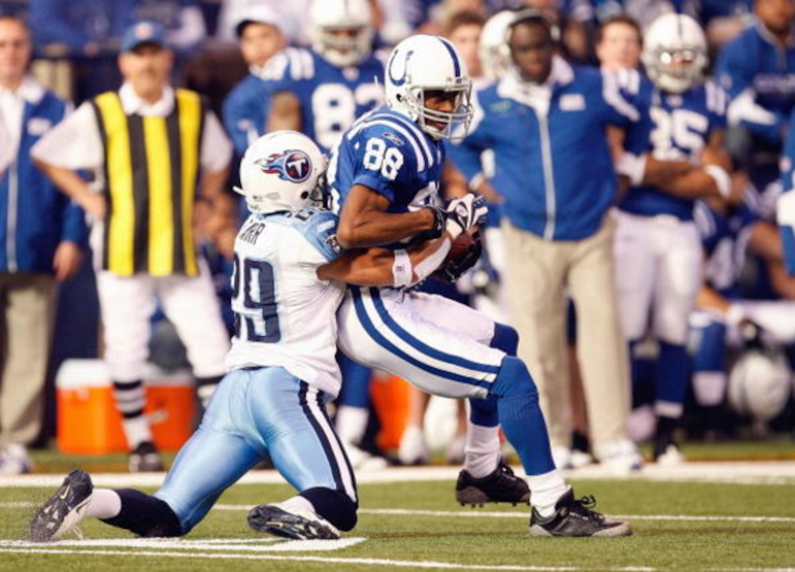 INDIANAPOLIS - DECEMBER 28:  Marvin Harrison #88 of the Indianapolis Colts grips the ball as he is sacked by Chris Carr #29 during the game against the Tennessee Titans on December 28, 2008 at Lucas Oil Stadium in Indianapolis, Indiana. (Photo by: Jamie S